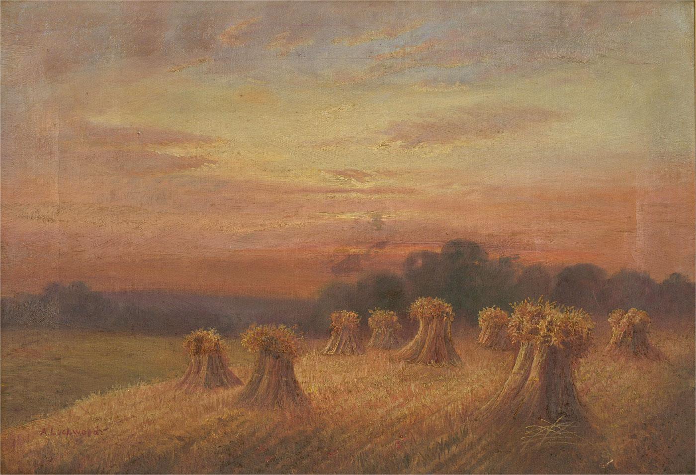 This charming landscape study depicts freshly harvested haystacks before a sunset. Painted in fine detail using a subtle impasto technique to create depth and texture. Signed to the lower left. Presented in a simple gilt frame. On canvas on