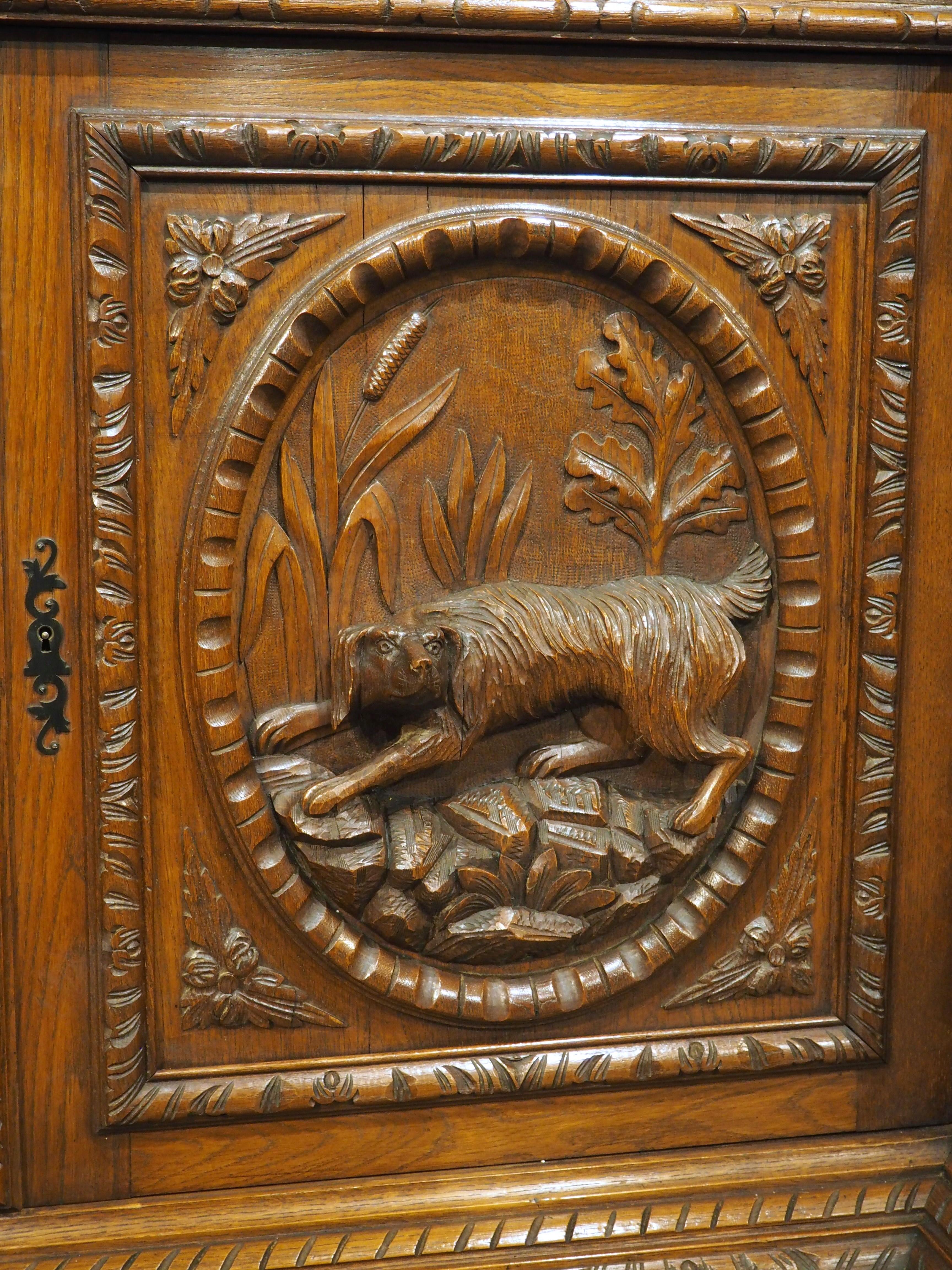 At over nine feet wide (109 ¼ inches), this long oak hunting lodge buffet enfilade would make a wonderful addition to a dining room, living room, or game room. Hand-carved in France, circa 1890, the enfilade features thick and well-defined carvings