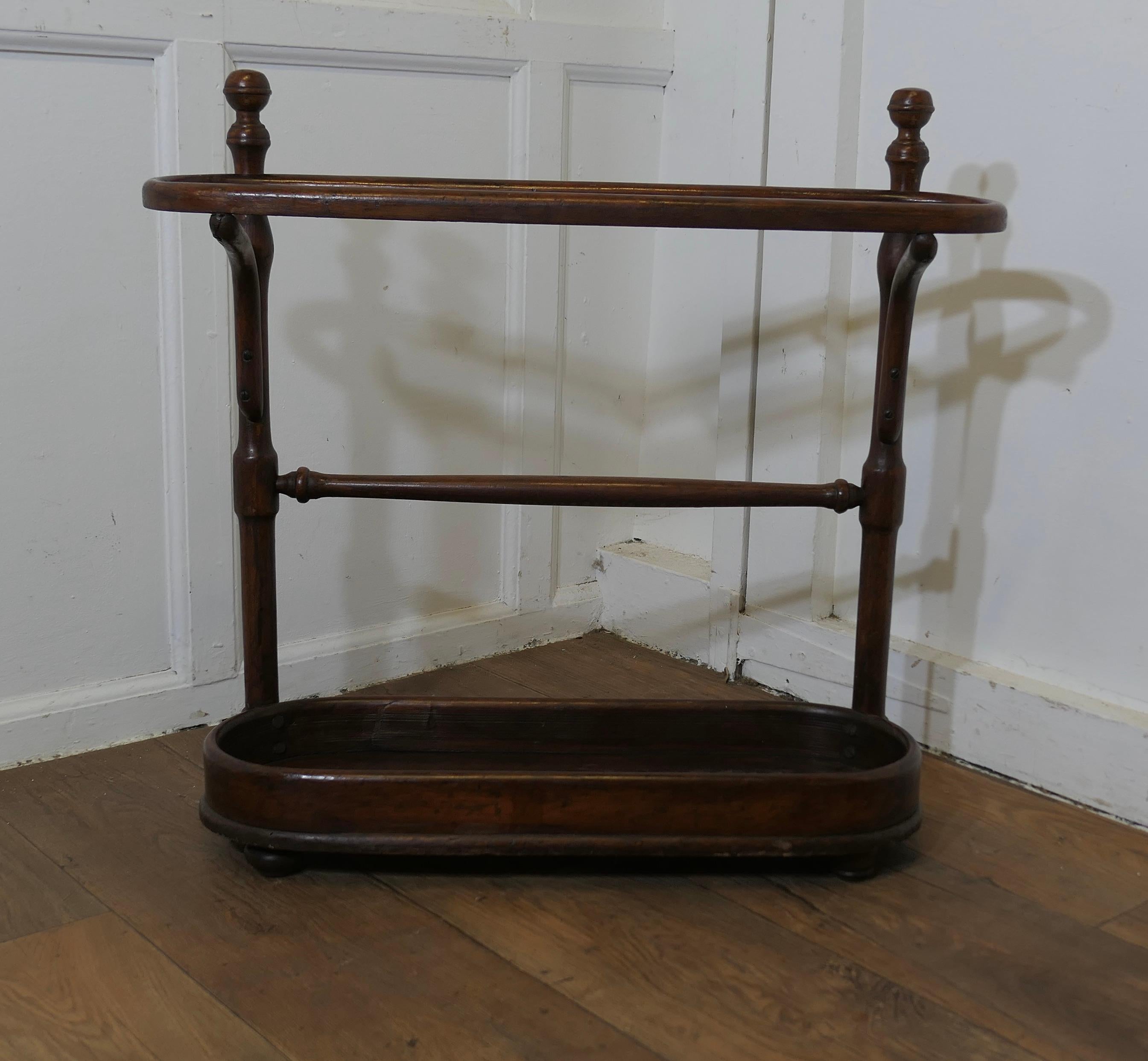 A Long Bentwood Stick Stand or Umbrella Stand

This is a good Umbrella stand, it is long with curved ends
The top is  divided into 3 sections and it will hold a lot of Walking Sticks,Umbrellas, Tennis Rackets anything kept in the hall and it works