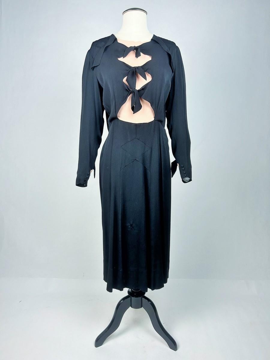 Circa 1938 - 1942

Germany

Elegant long dress in black and salmon artificial silk crepe, collected in Berlin, dating from the late 1930s. Straight cut, long sleeves with geometric triangles typical of the period. An ingenious salmon-coloured silk