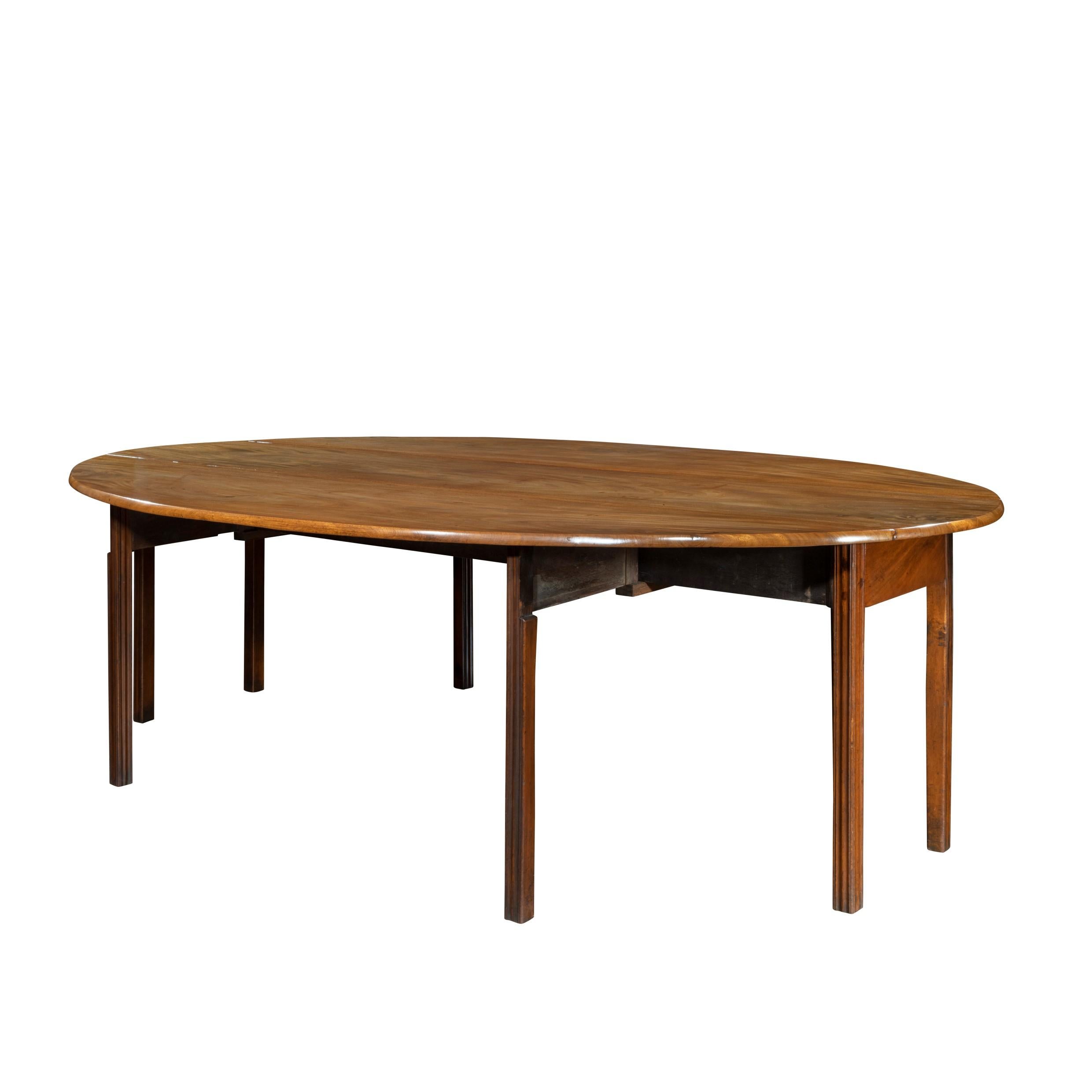A long early George III Irish mahogany dining or wake table of exceptional colour, the highly figured veneered oval top with two drop flaps down over eight reeded gate legs, seats 12, Irish, circa 1760.
 
Measures: H 28 ½ in W open 62 in closed