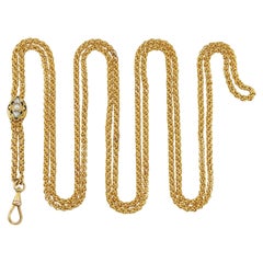 A long gold chain with diamond-set cursor