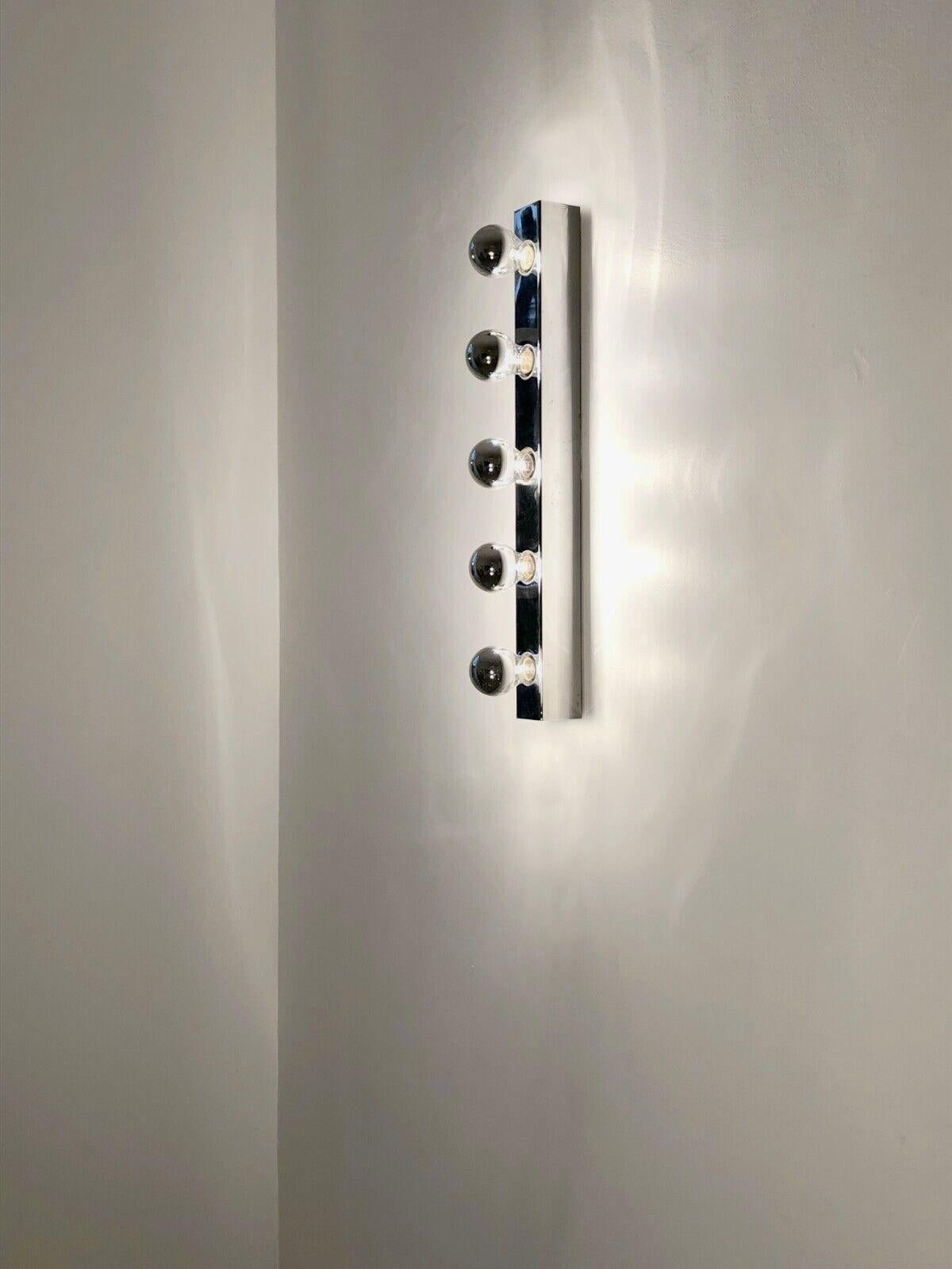 A large wall light or wall light bar type artist's dressing room or bathroom, Minimalist, Pop, Modernist, Space-Age, long rectangular base in chrome metal with rounded edges, with 5 circular openings for 5 screw bulbs creating a beautiful graphic