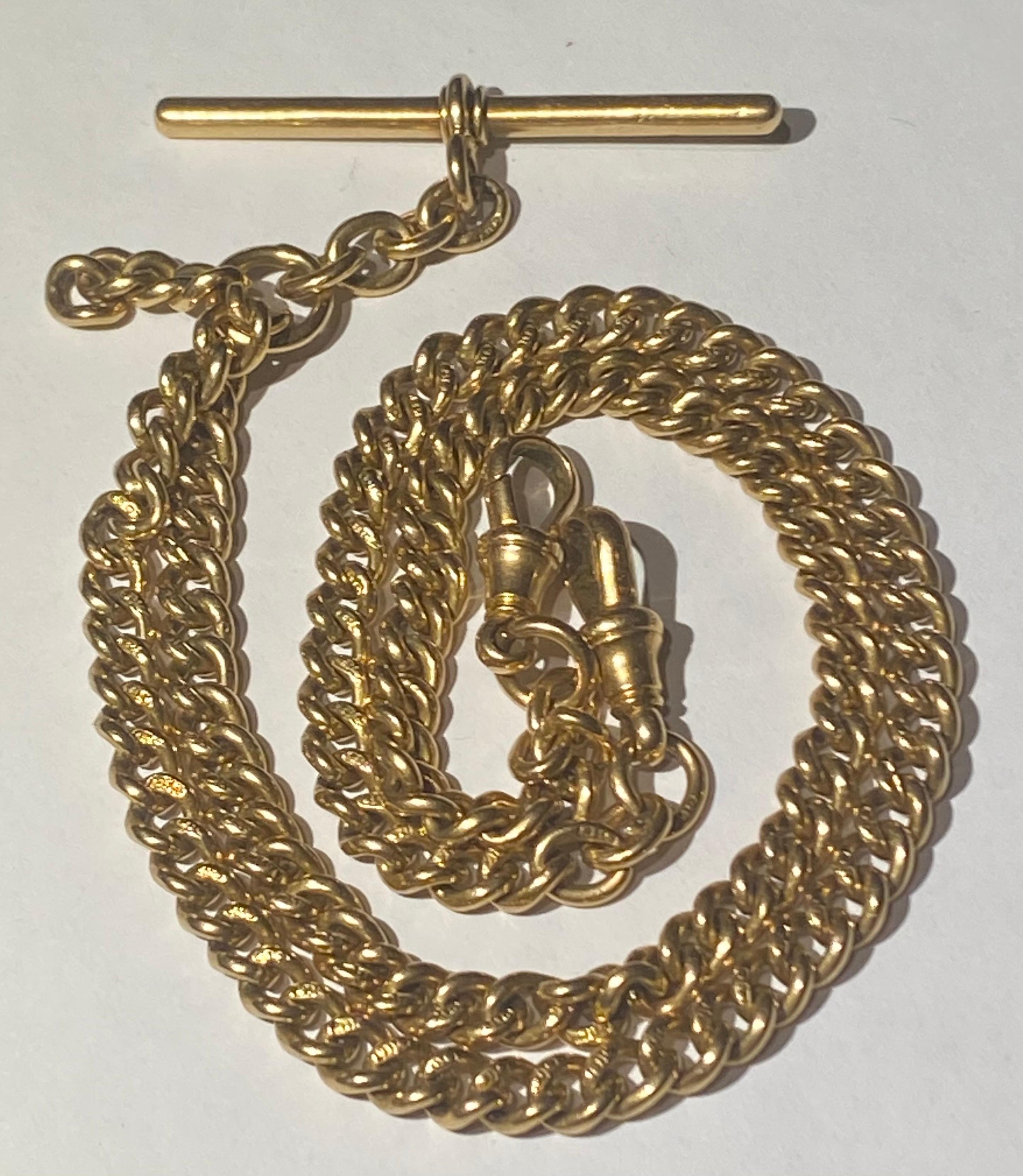  A Victorian antique solid 18 carat yellow gold curb link double Albert watch chain with T-bar and a pair of dog clips  c 1890
The chain, T-bar and dog clip are marked 18 and crown for 18 carat solid gold. All the individual links are hallmarked 18