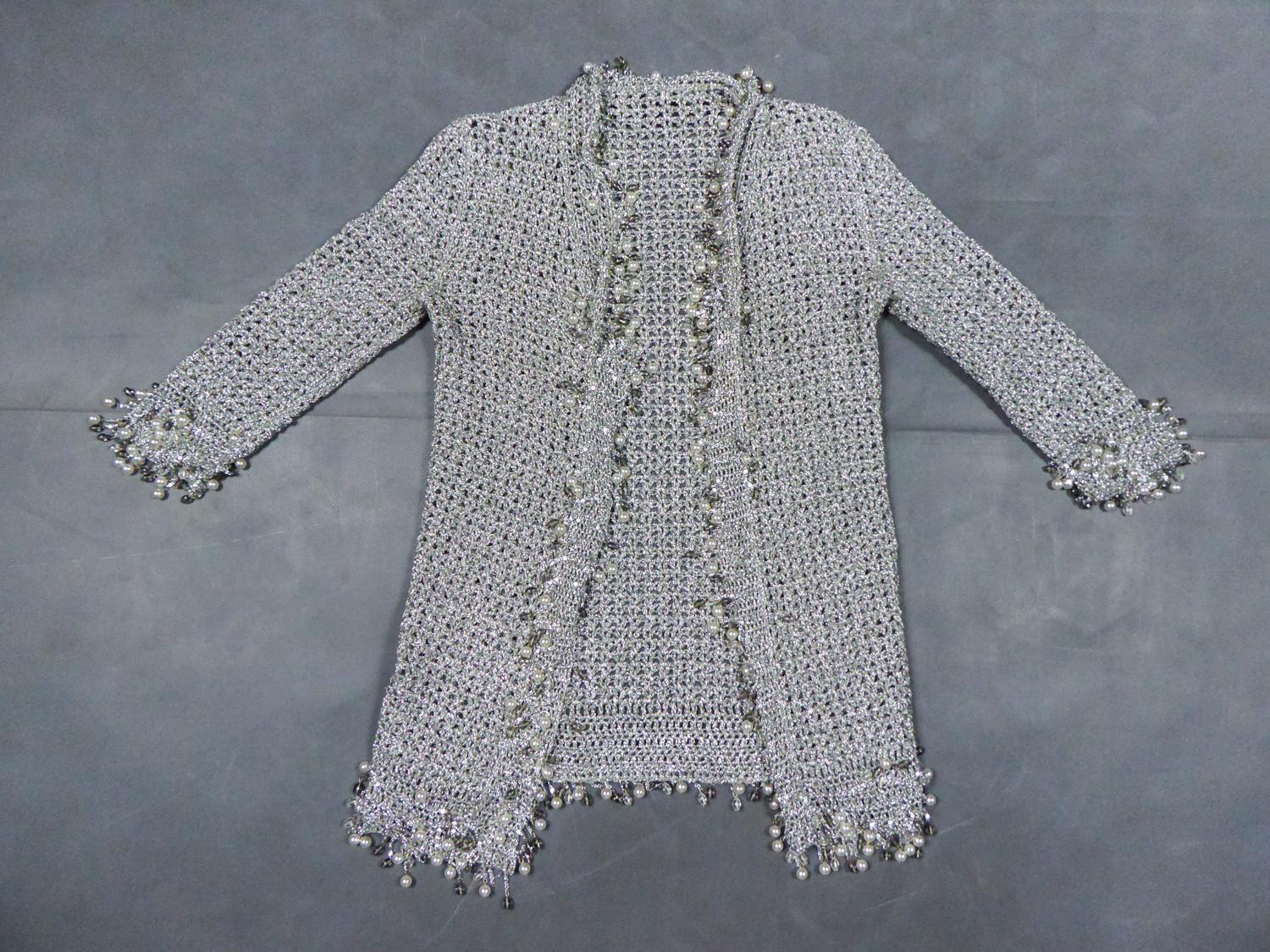 Circa 1970/1980
France

A Loris Azzaro (attributed to) evening jacket in silver lurex stitch dating from the 70s. Jacket with wide stitches, rim of the jacket including sleeves, collar, closure and bottom of the jacket in tassels of silver chains