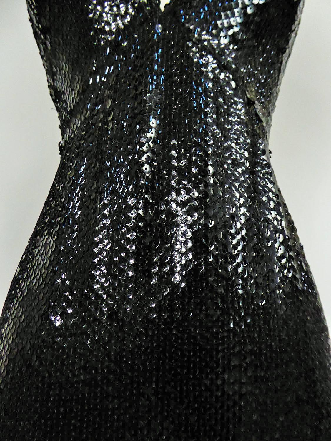 Circa 1970/1980
France Paris

Loris Azzaro Haute Couture evening dress embroidered with black sequins dating from the 70's. Entirely embroidered with black sequins superimposed like fish scales. Skin-tight dress and halterneck with large V-neck in