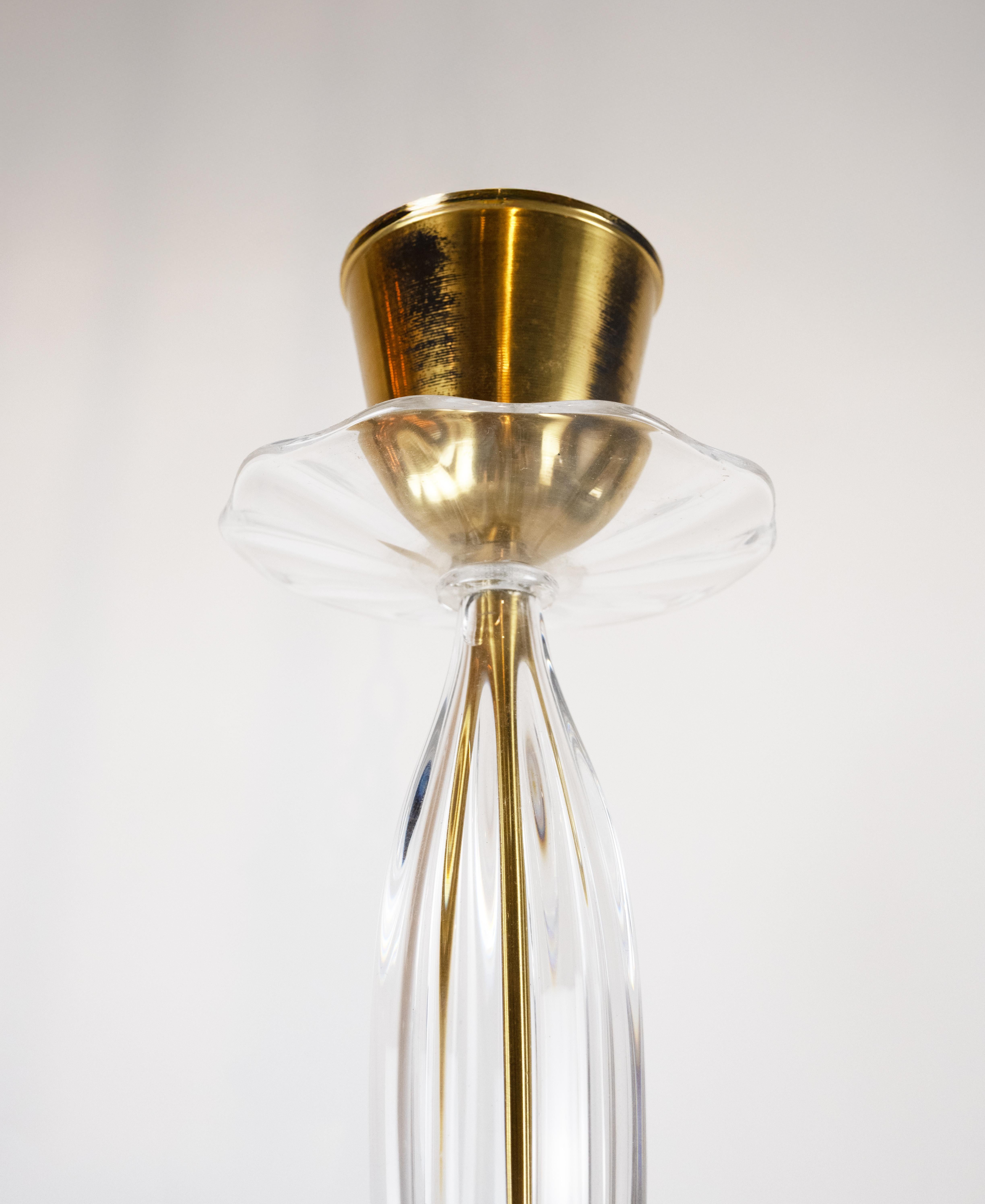 Una plafoniera svedese di Orrefors a forma di fiore di loto, con petali composti da singole sezioni di vetro trasparente testurizzato. Il gambo è inguainato in un altro manicotto di vetro scanalato. Circa 1950, il prezzo include un nuovo cablaggio