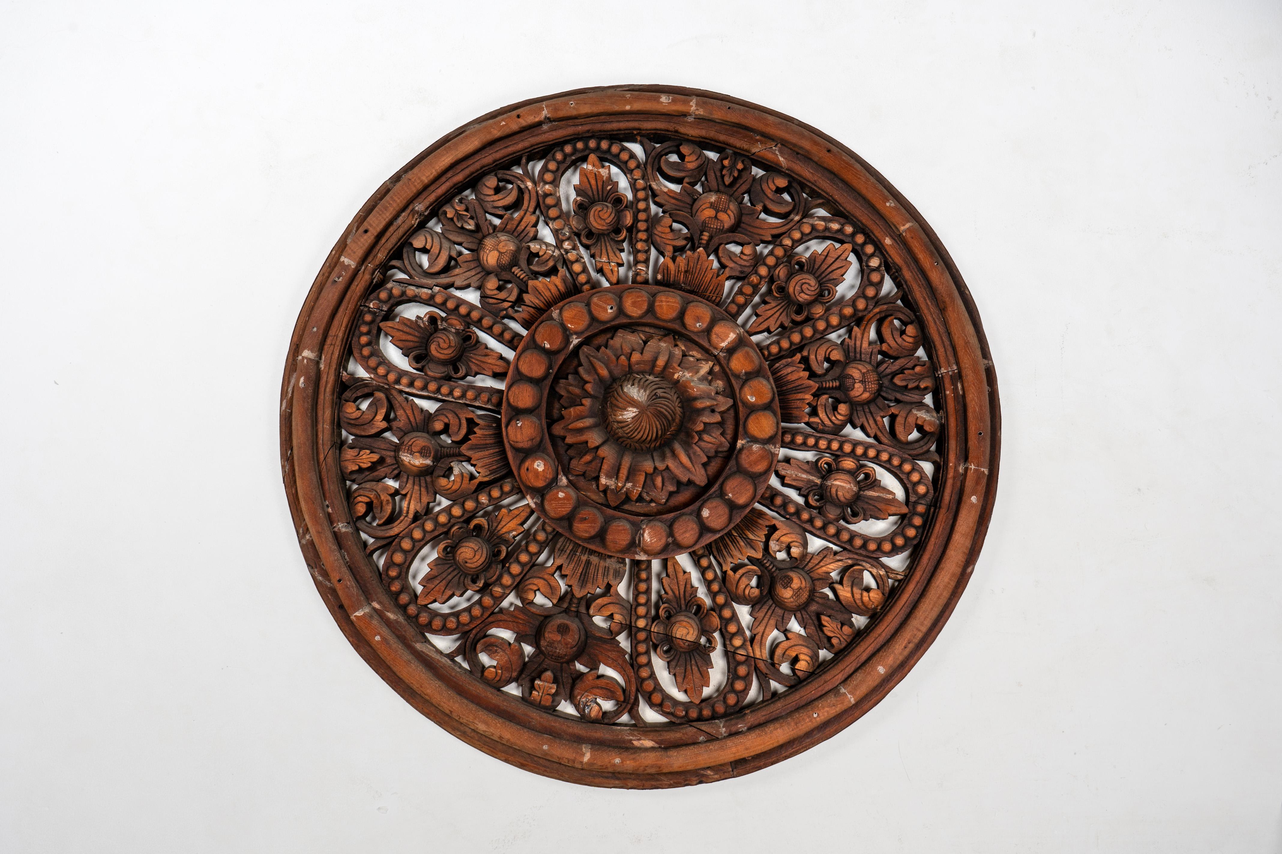 Intricately hand-carved, the panel depicts a central medallion of a lotus flower and leaves from Thailand and made from teak wood. Originally these circular  medallions were found only on temple ceilings and usually covered in gold leaf. The chief