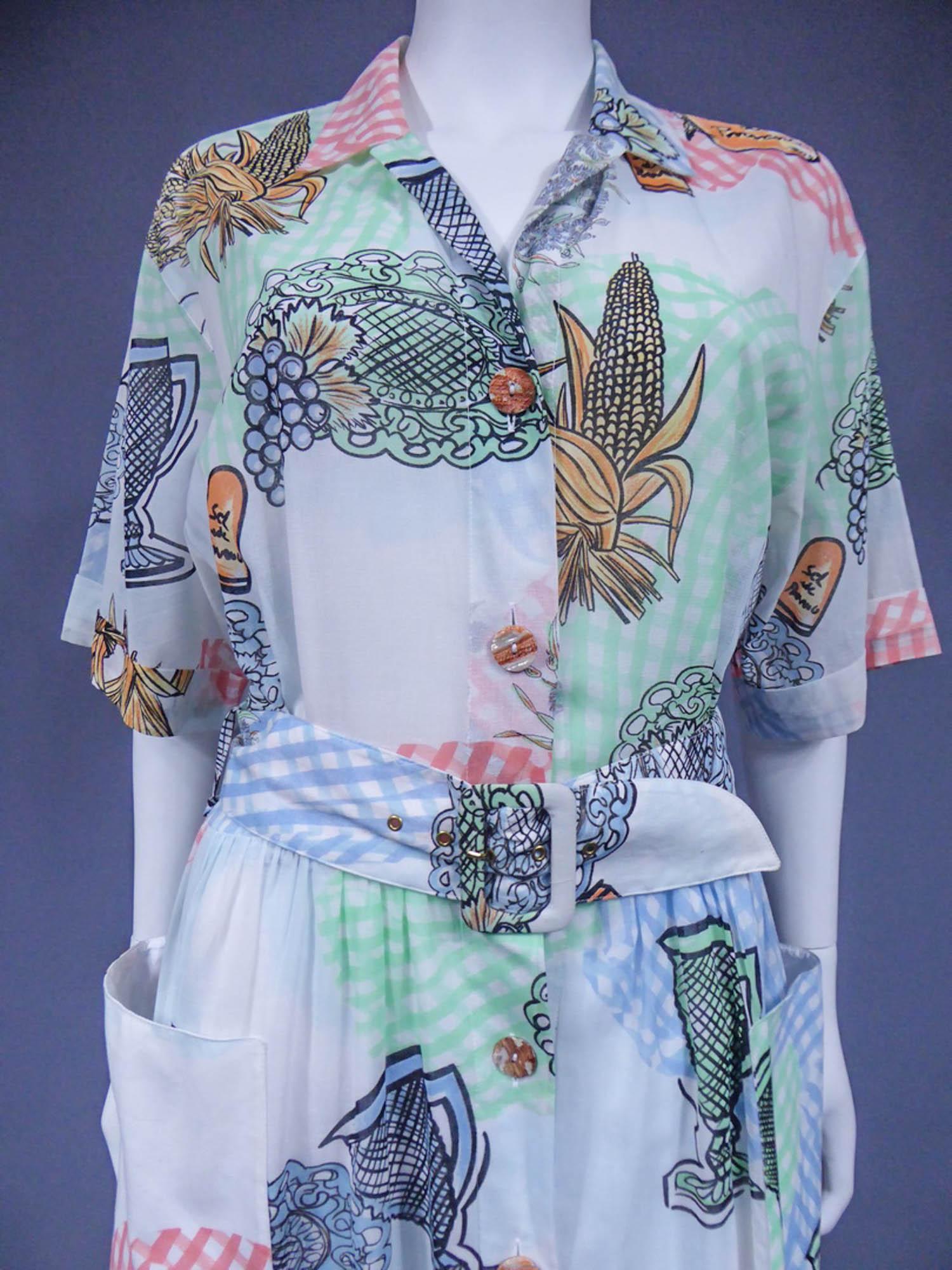 Um 1970
Frankreich

Kleid aus bedrucktem Polyamid im provençalischen Stil von Louis Féraud aus den 1970er Jahren. Kurzärmeliges Modell, passende Gürtelschnalle und weites Rockfutter. Öffnung auf der Vorderseite mit passenden Harzknöpfen.