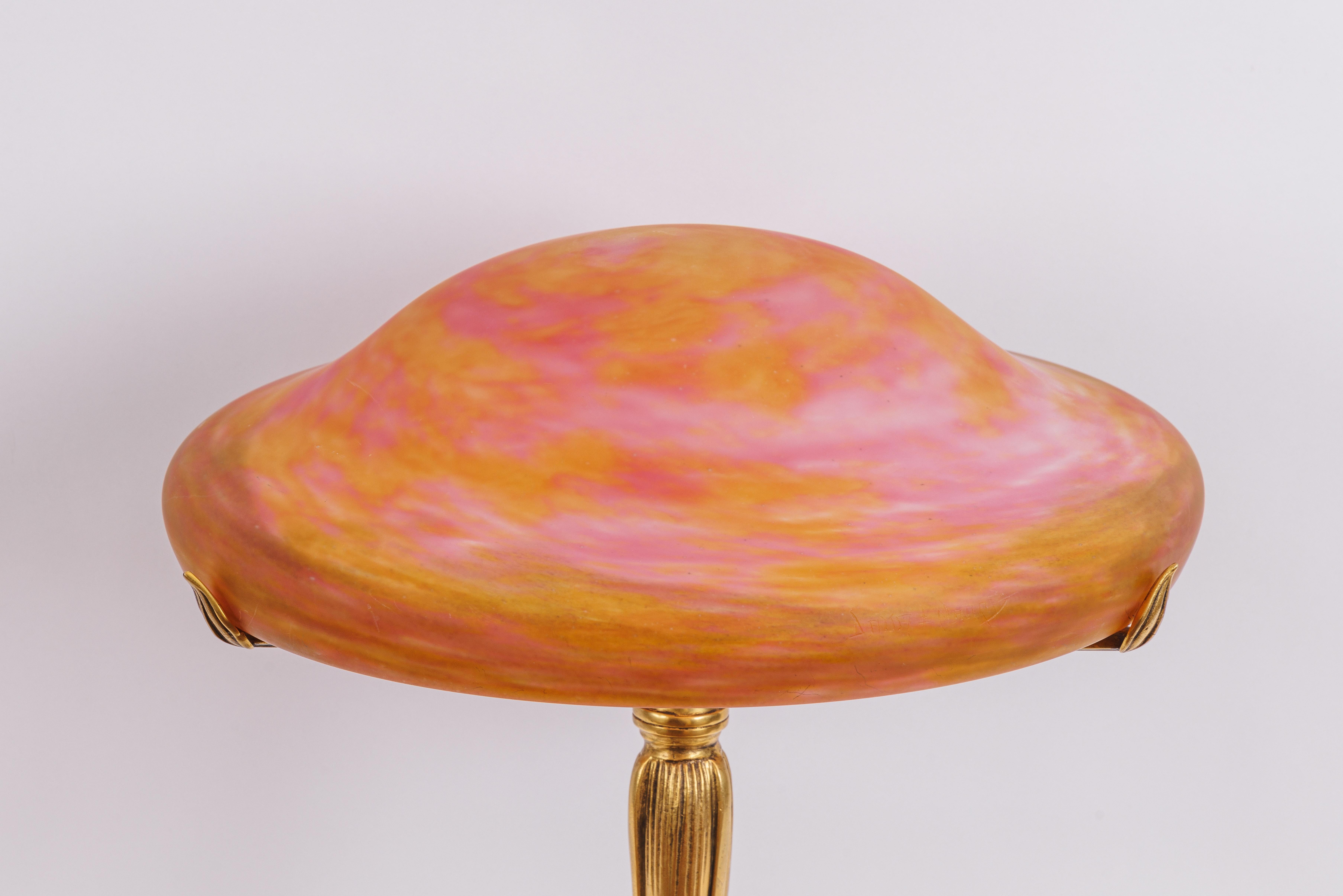 A Louis Majorelle and Daum Nancy Gilt Bronze and Pink Glass Table Lamp, Circa 1900

Introducing an exquisite piece of Art Nouveau mastery – the Louis Majorelle and Daum Nancy Gilt Bronze and Pink Glass Table Lamp, a timeless treasure hailing from