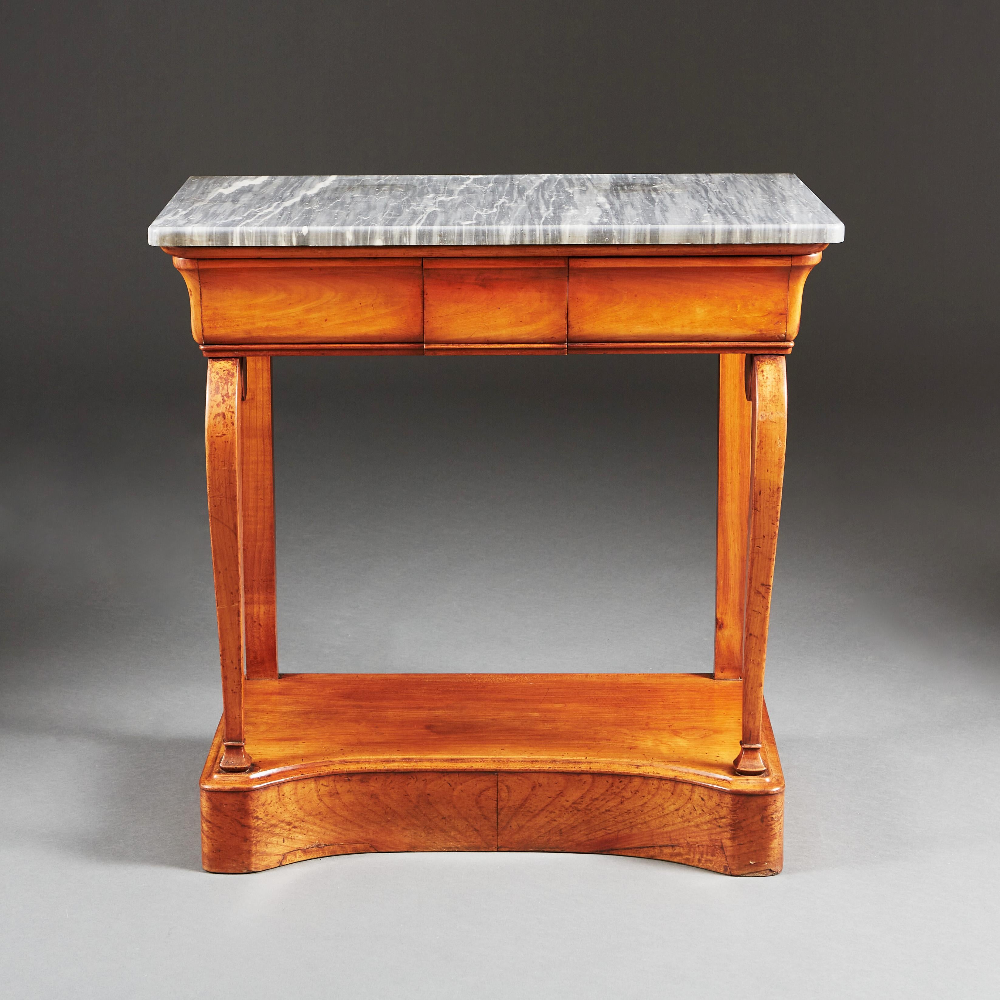An early 19th century cherrywood console table with original grey marble top, with one drawer to the frieze, the scrolling front uprights standing on a concave front base.