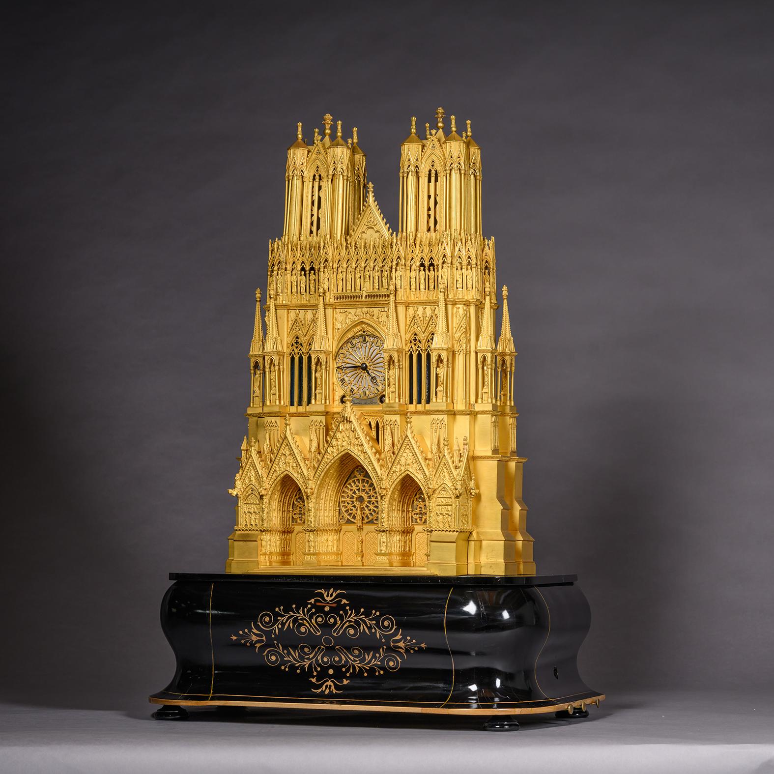 A Louis Philippe Gilt-Bronze 'Reims Cathedral'  Musical Mantel Clock, The Clock Movement By J. Charles, Paris. The Musical Movement By Martinet & Benoit, Geneva. 

Modelled as the West facade of Reims Cathedral. The twin-towers above the gallery of