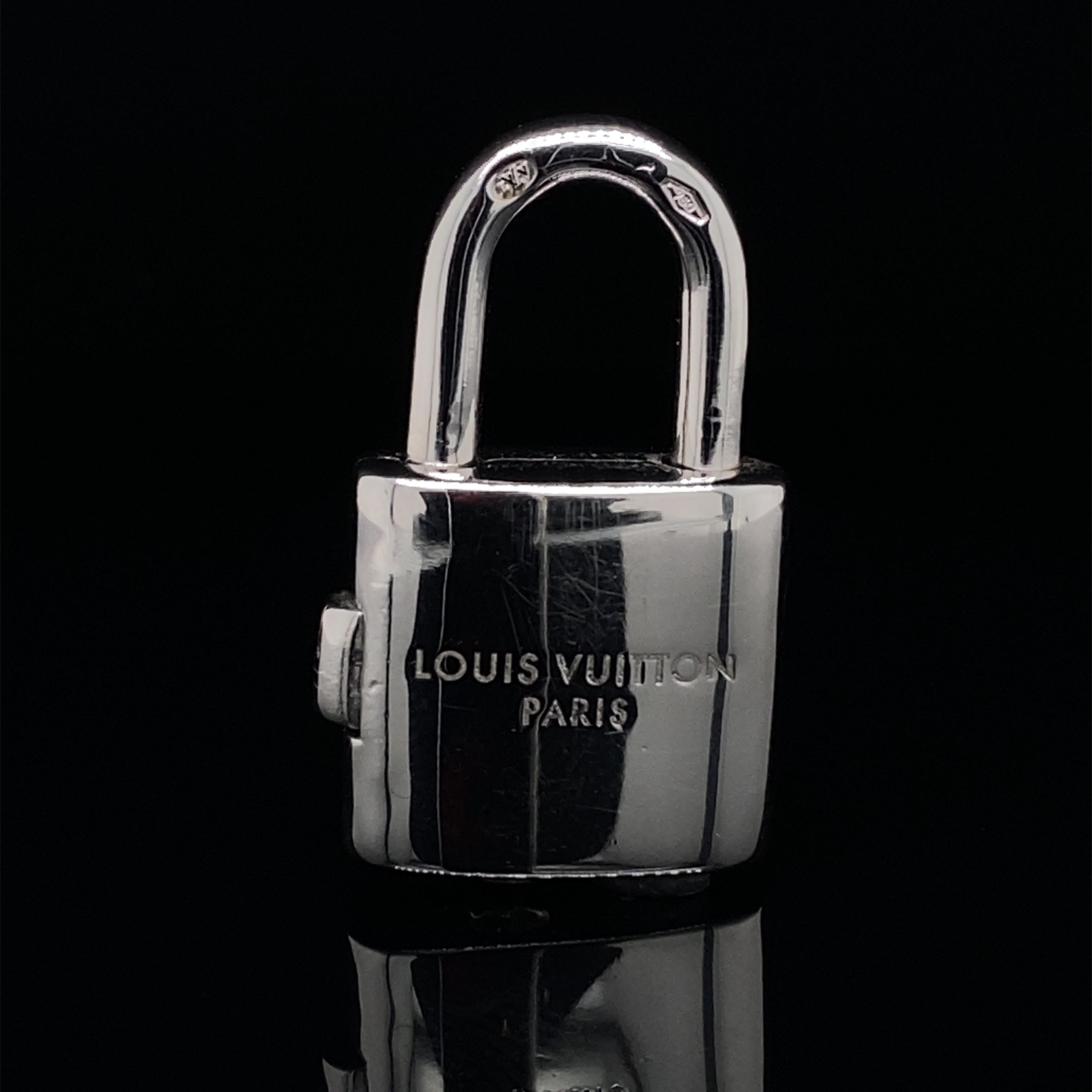 A Louis Vuitton 18 karat white gold padlock charm with chain.

This sweet charm has a release catch to its side which opens up the padlock allowing it to be attached to a bracelet or chain. It currently sits on a fine 16 inch 18 karat white gold