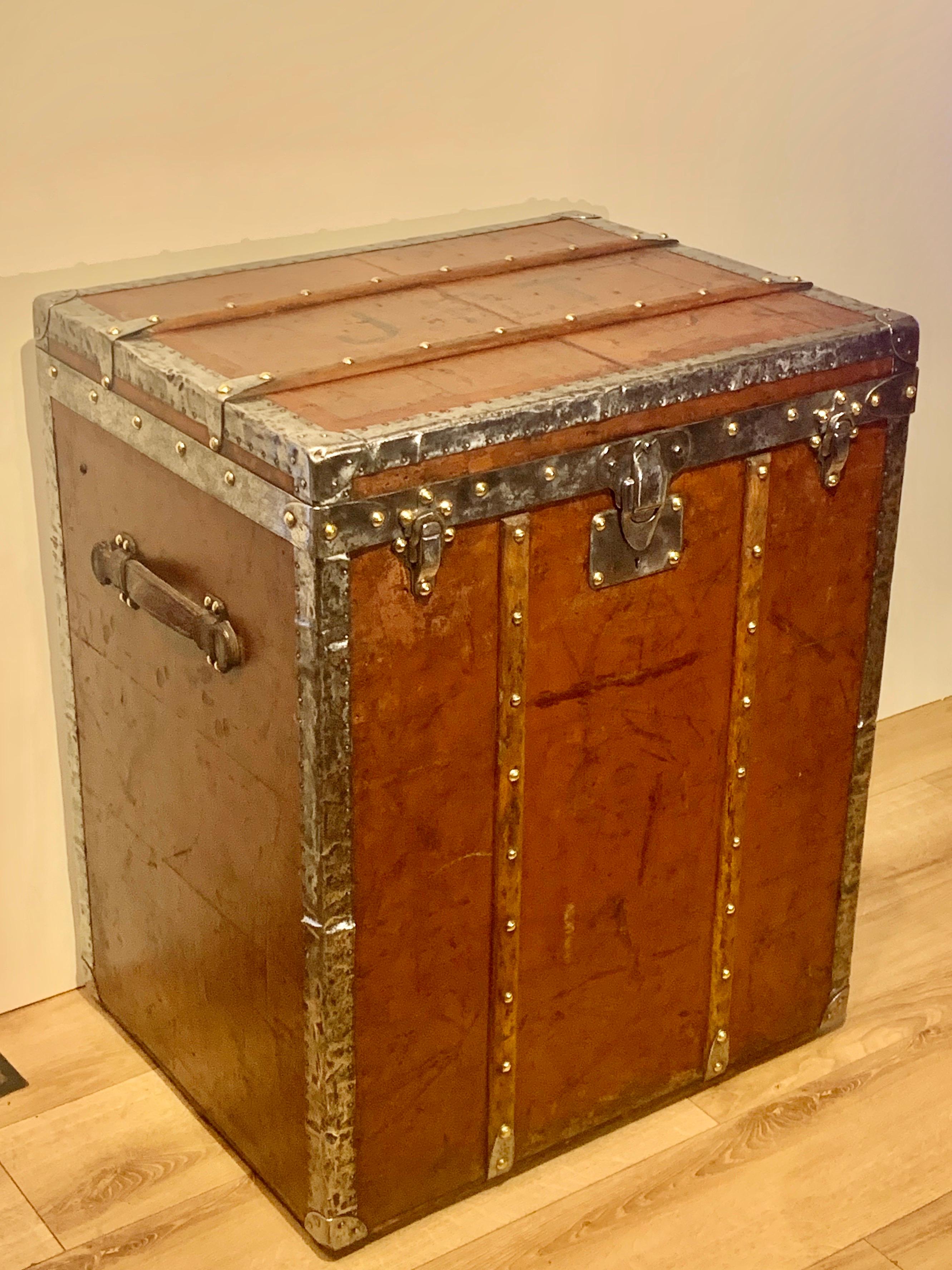 A Louis Vuitton Trunk, dating from the late 19Th to the early part of the 20th century (circa 1890/1910). Covered in Vuittonite canvas, this vertical trunk is rarer than the monogrammed examples with its stain and water resistant canvas with metal