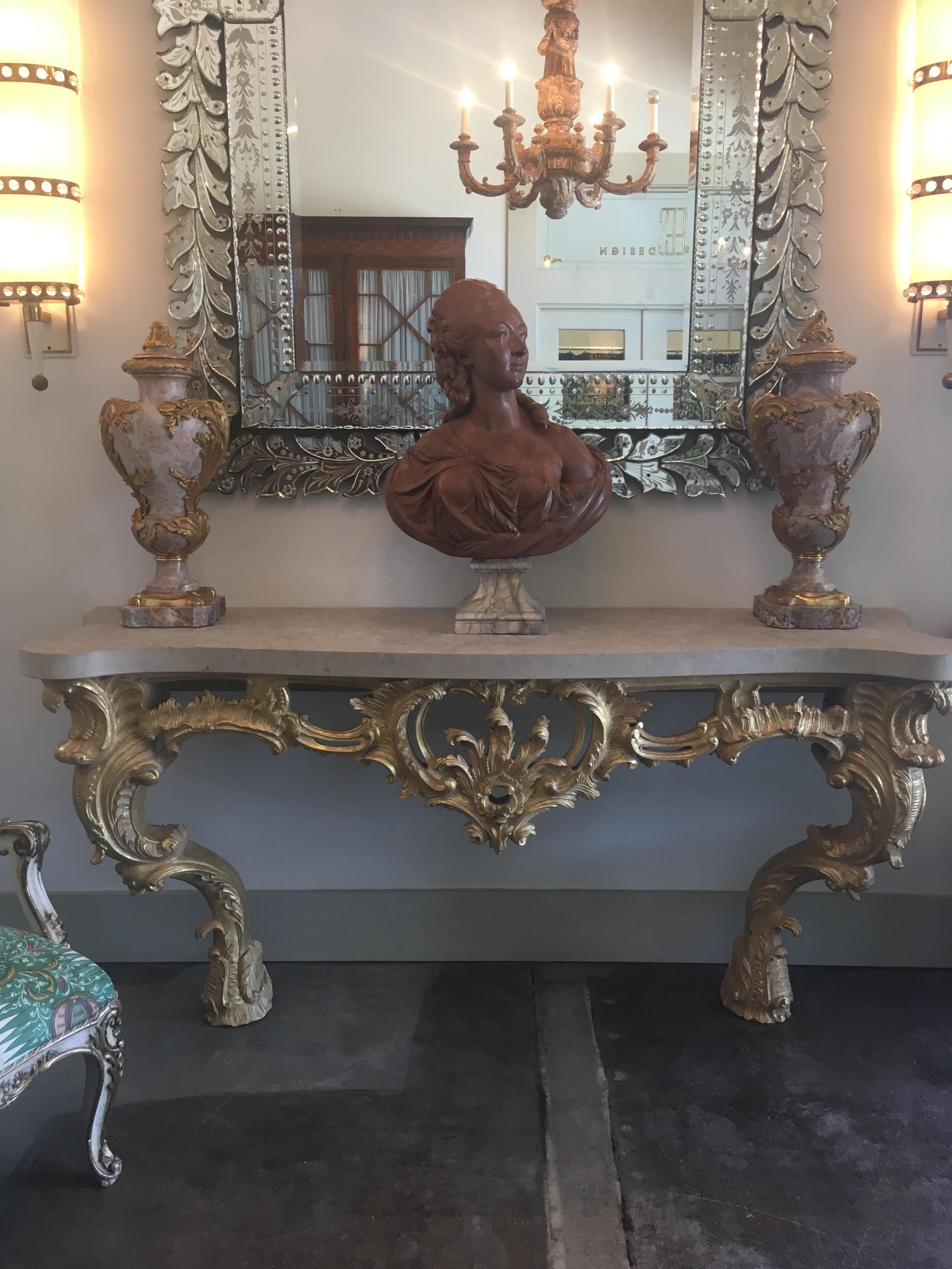 This breathtaking Louis XV Rococo Style carved and gilded wood wall console features elaborate and very fine carvings throughout including acanthus scrollwork and deep shell carvings. The intricate facade is in d'arbalete form and features a honed