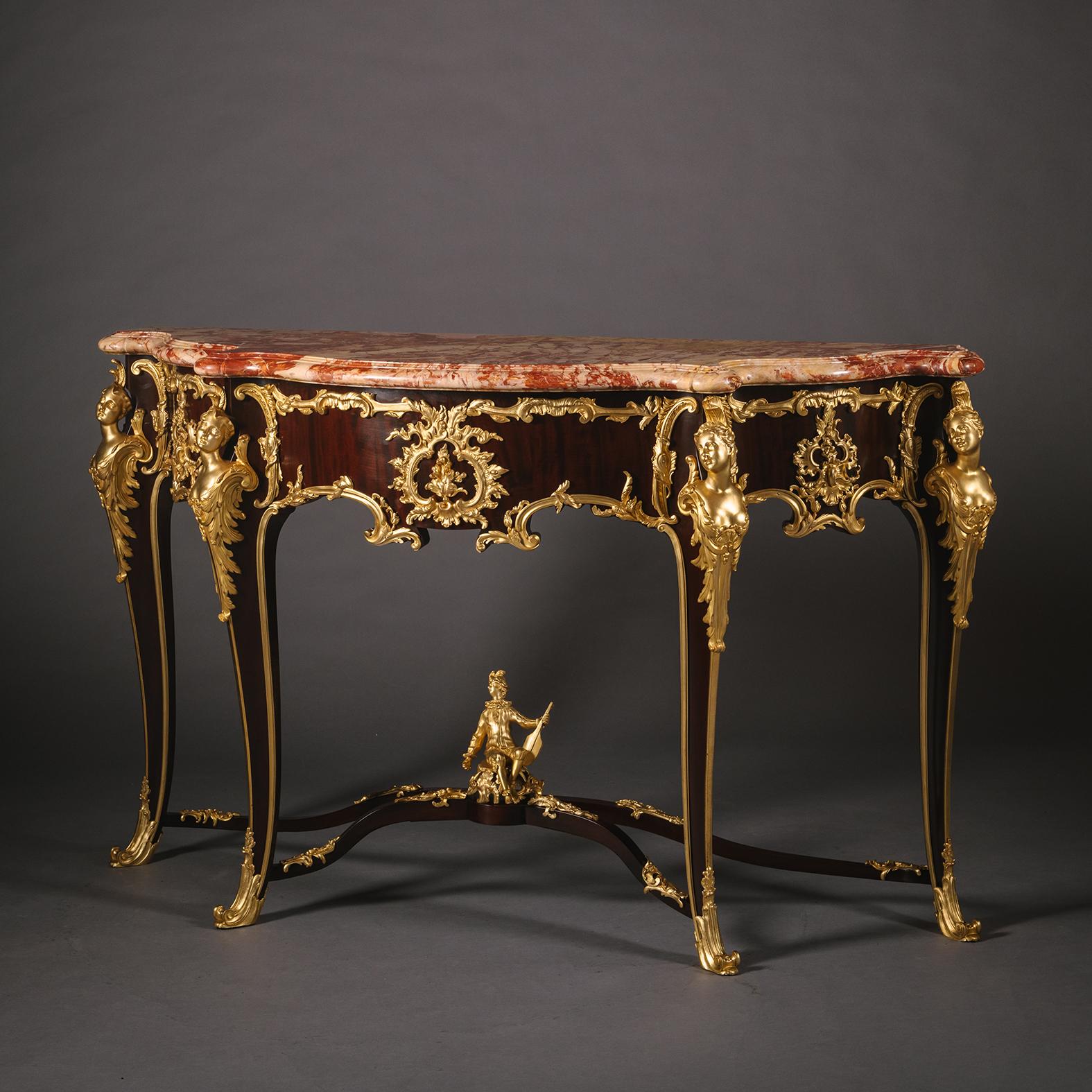 A Louis XV Style Gilt-Bronze Mounted Mahogany Console Table, With Marble Top, By François Linke, Paris.

Surmounted by a serpentine-shaped Brèche de Saint-Maximin marble top. The frieze with acanthus cast naturalistic frame encircling central