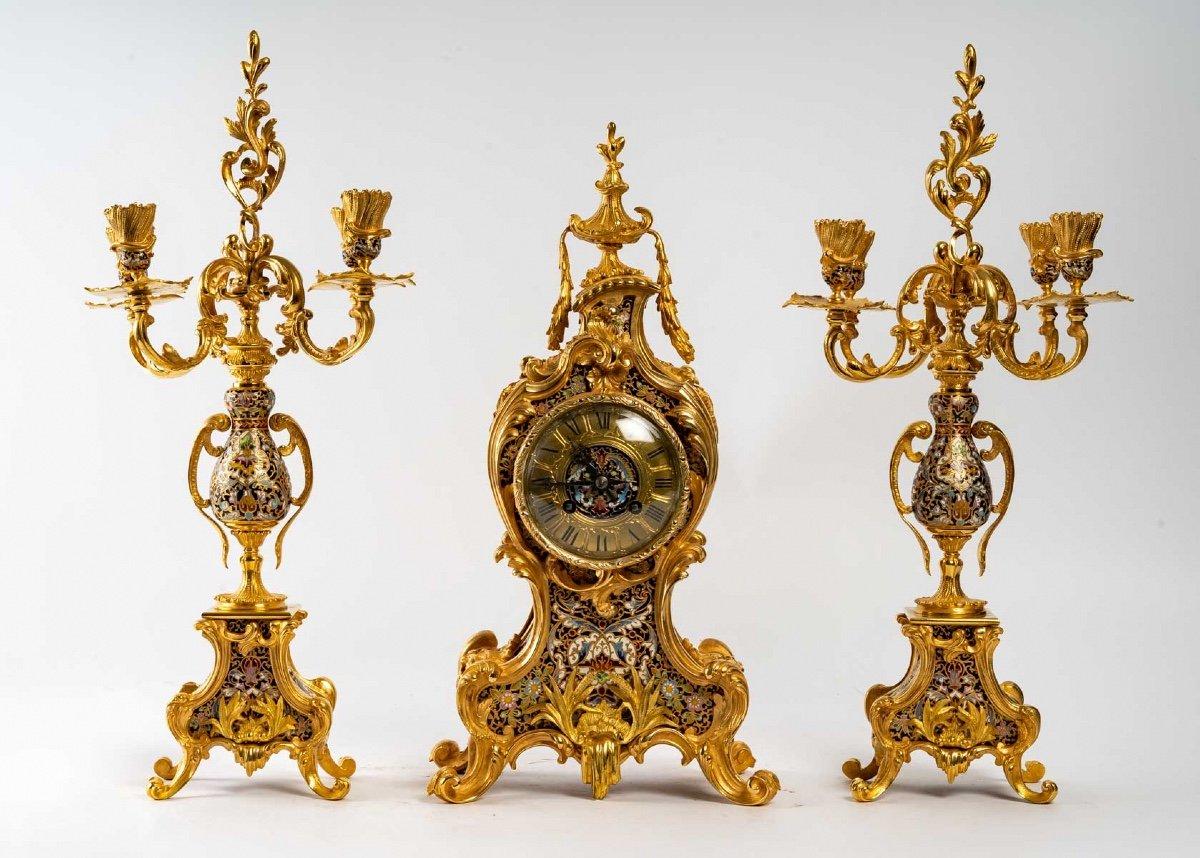A Louis XV style gilt bronze and cloisonné enamel mantel set, Napoleon III period, late 19th century
Composed of a clock and a pair of candelabras with four lights
in the Barbedienne style, very good quality of chasing and gilding.
In perfect