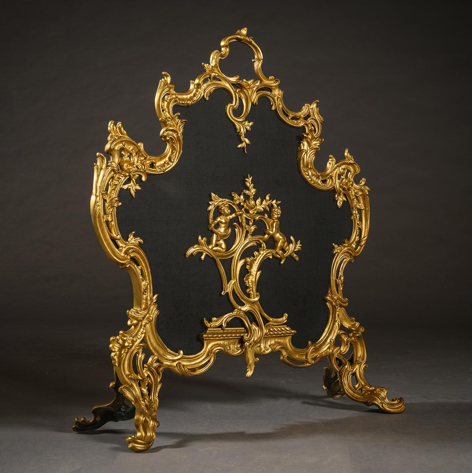 A Louis XV Style Gilt-Bronze Fire Screen.

Of cartouche outshape with a pierced frame cast with rocaille and scrolled acanthus enclosing a metal mesh screen centred by flowering bearing putti. Raised on scrolled legs.

France, Circa 1890.
