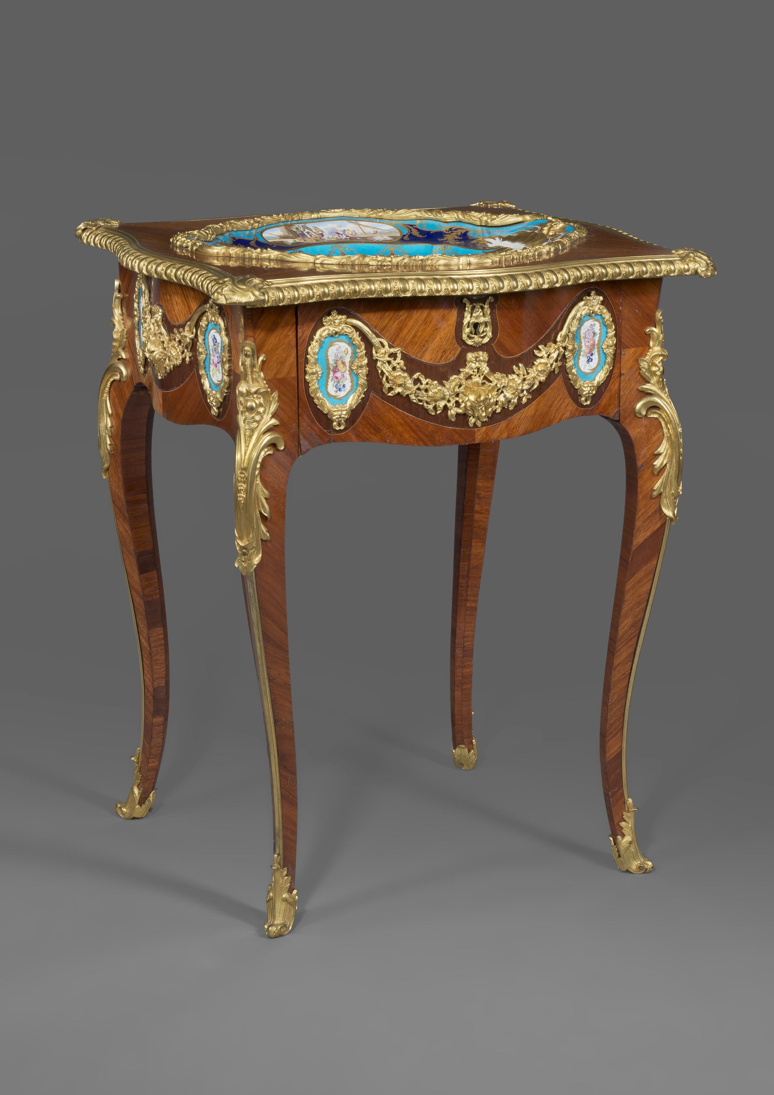 A Petite Louis XV style gilt-bronze mounted and Sèvres style porcelain set table. 

French, circa 1870. 

This elegant table has a shaped rectangular top with gilt-bronze encadrement, inset with a superb Sèvres style oval dish. The dish has a