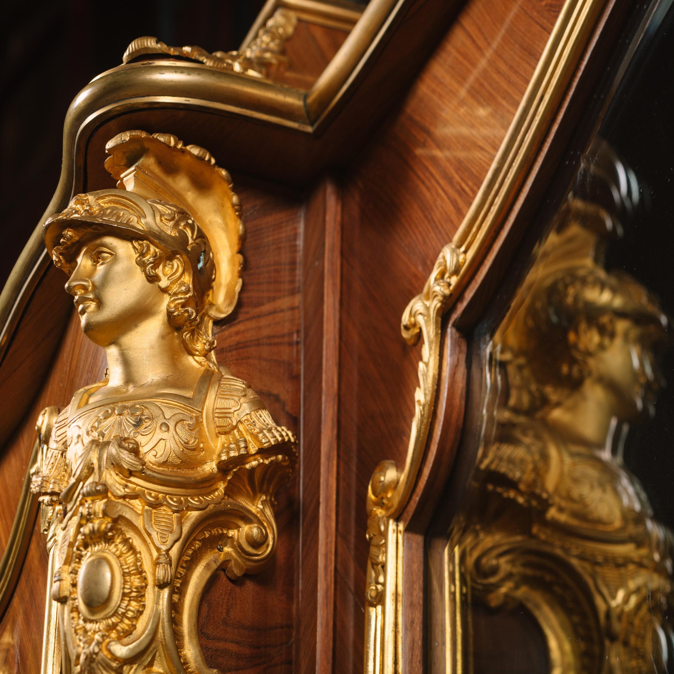 Eine vergoldete Bronzemontierung im Stil Ludwigs XV., die François Linke zugeschrieben wird.

Dieses Bücherregal ist reichlich mit Ormolu beschlagen, insbesondere die Soldatenbüsten an den Ecken, die als 