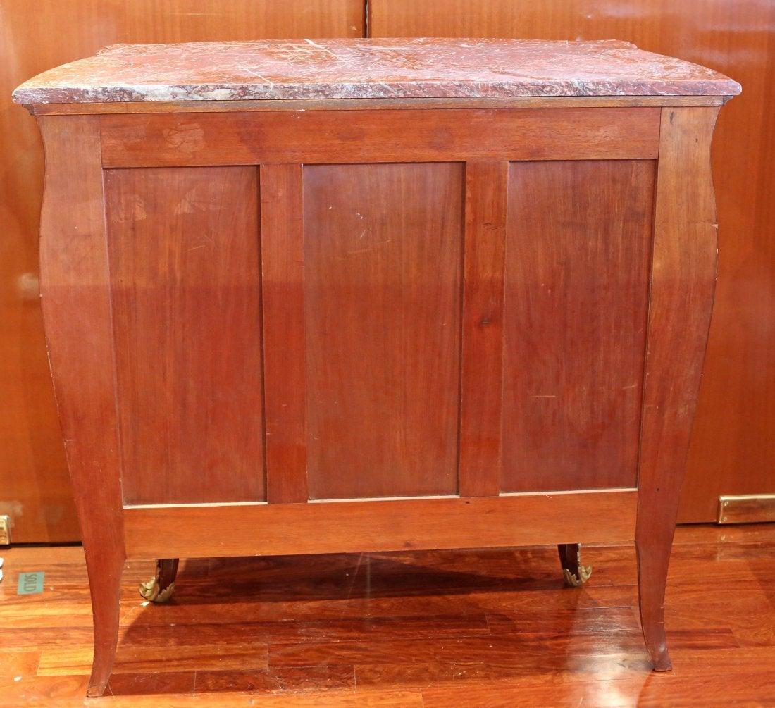 A Louis XV style Kingwood and rosewood parquetry side cabinet by Francois Linke, #204,
Paris, circa 1900. The marble top of serpentine outline above a bombe' case with a pair of cupboard doors adorned with gilt-bronze scrollwork opening to an