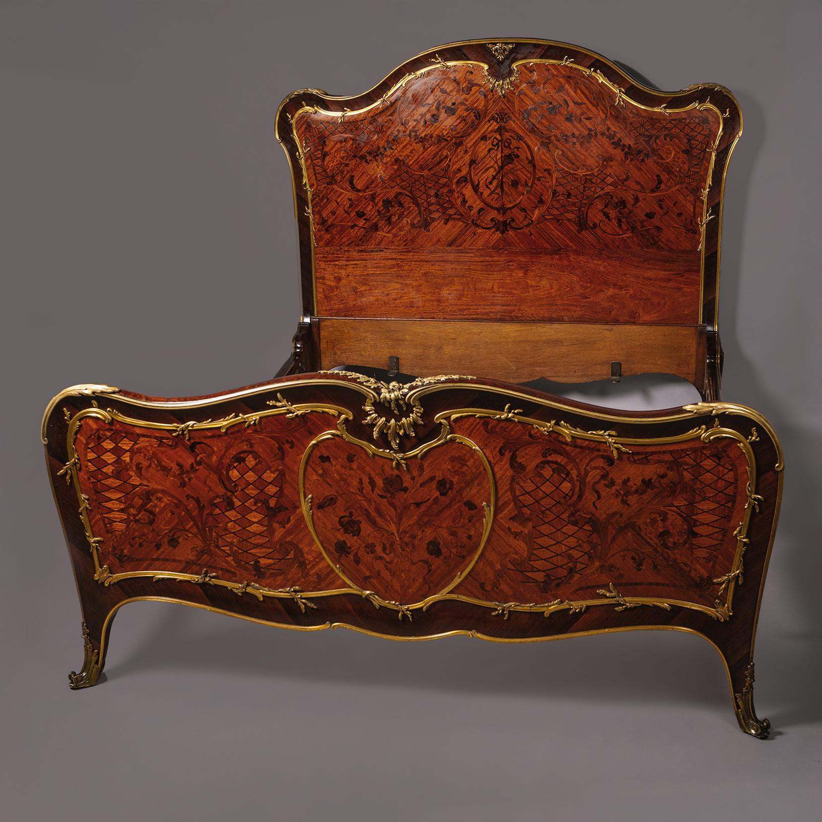Lit double de style Louis XV en marqueterie de bronze doré, attribué à François Linke, Paris.

La tête de lit de forme serpentine avec fronton arqué monté avec des encadrements de rocaille en bronze doré entourant un panneau de marqueterie de bois