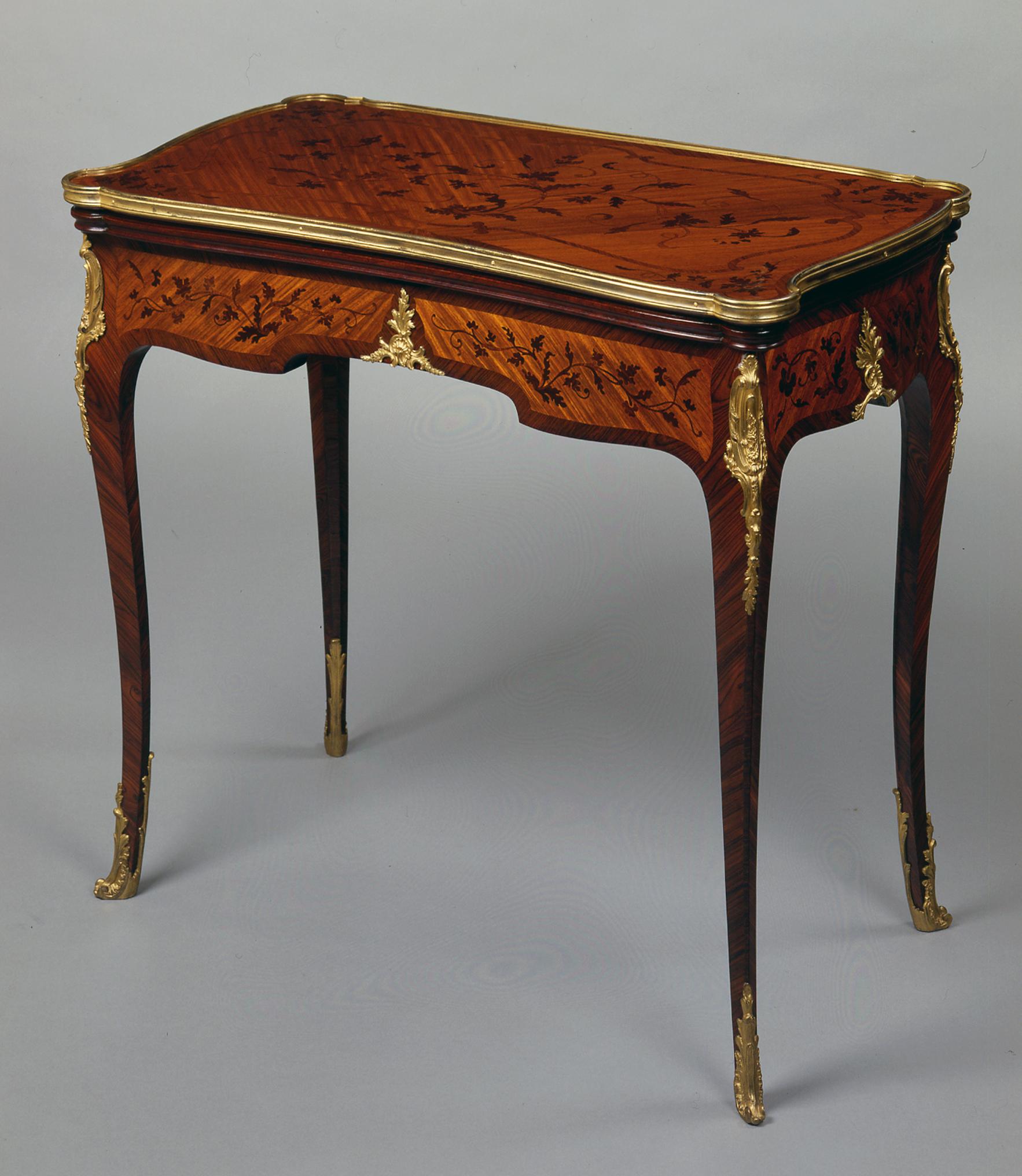A Louis XV style Marquetry games table.

French, circa 1870.

A Louis XV style Marquetry games table, the shaped rectangular top, with gilt bound edge, inlaid with delicate foliate tendrils above a similarly inlaid re-entrant apron, raised on