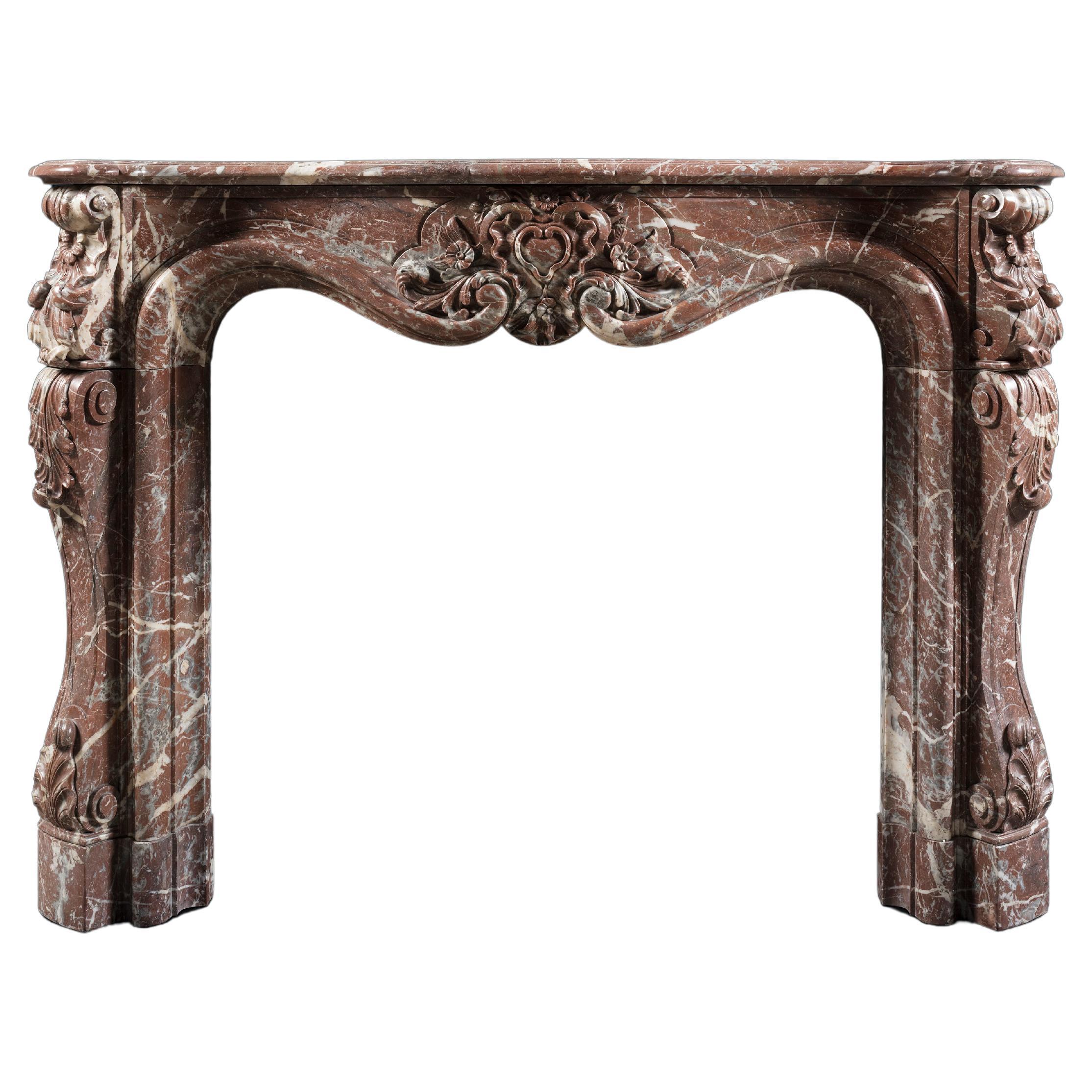 A Louis XV style Rococo Chimneypiece in Rosso Antico Marble For Sale