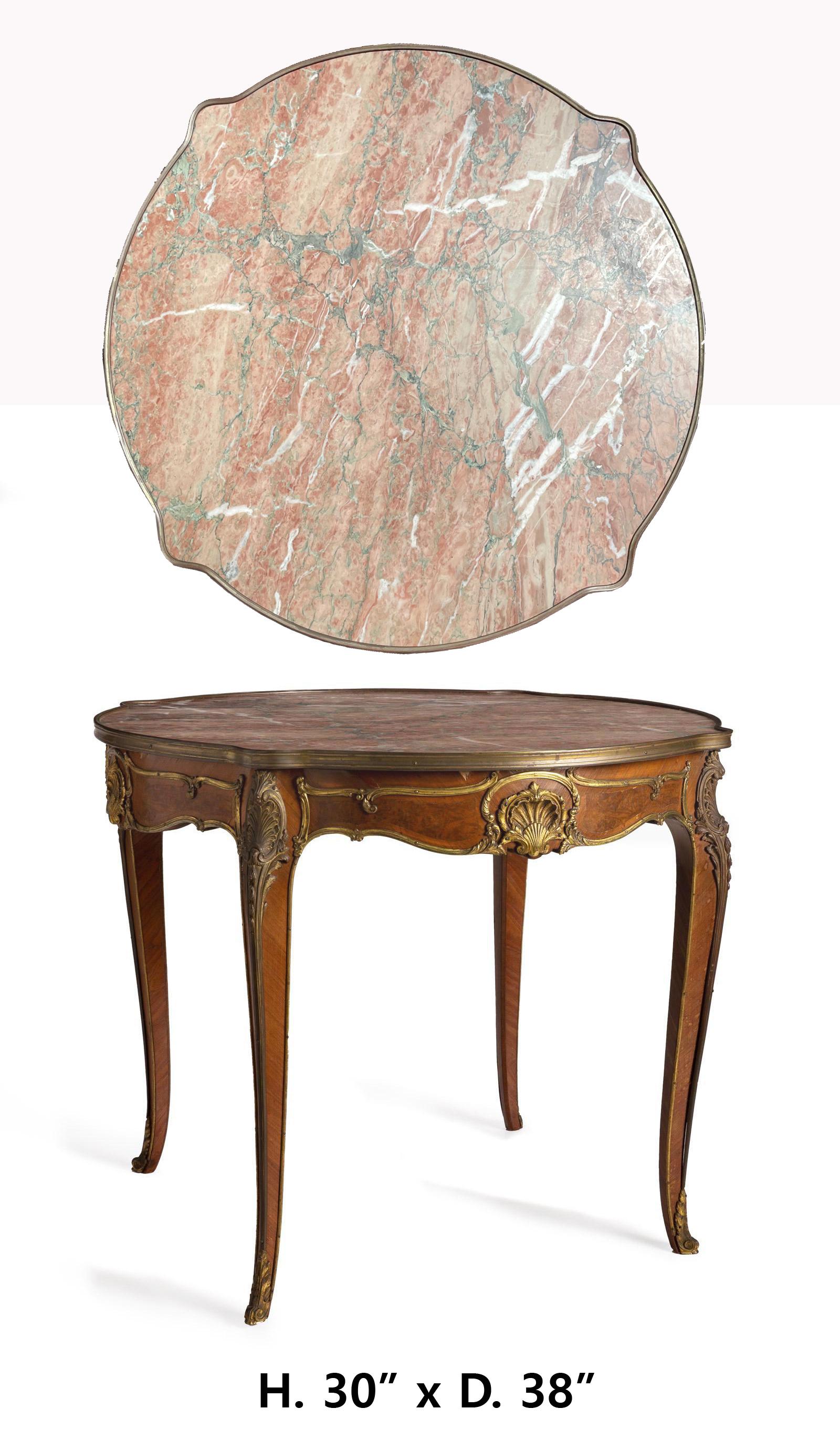 Beautiful 19c French Louis XV-style table gilt bronze mounted center table
circa 1900
The round table with inset pink and grey marble top over a shaped apron with rocaille motif gilt-bronze mounts, raised on four cabriole legs with sabots to the