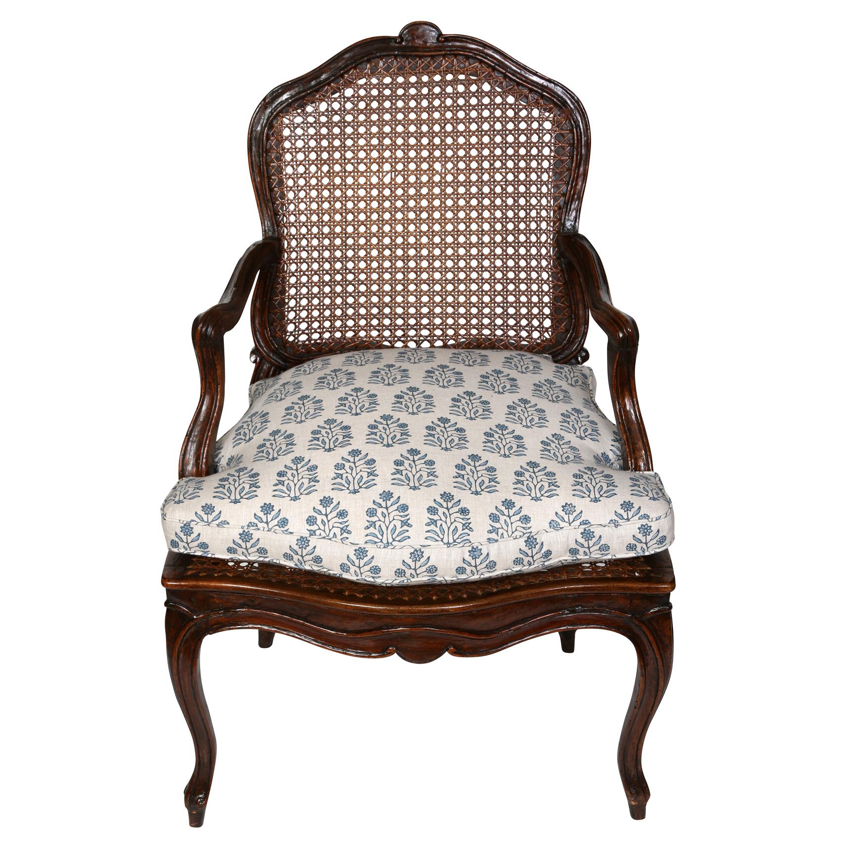 This charming little walnut arm chair has a caned seat and back, with cabriole legs and a lovely Walter G linen cushion--perfect as a side or desk chair. 
