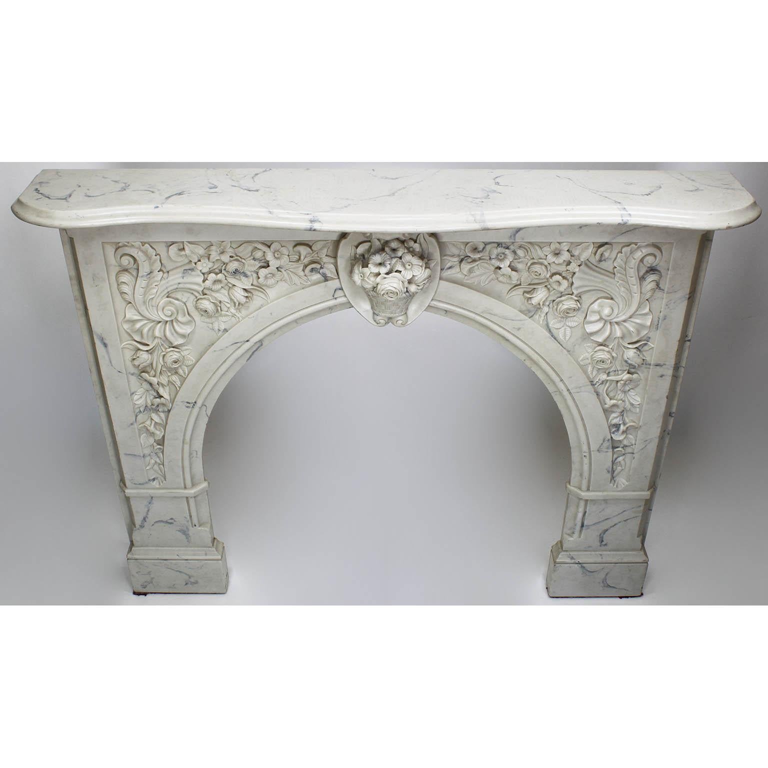 A Louis XV style white and veined Carrara color cultured cast-marble fireplace mantel. The ornately detailed mantel centered with a basket of flowers flanked by floral and shell themes, circa 20th century.

Measures: Shelf width 59 inches (149.9