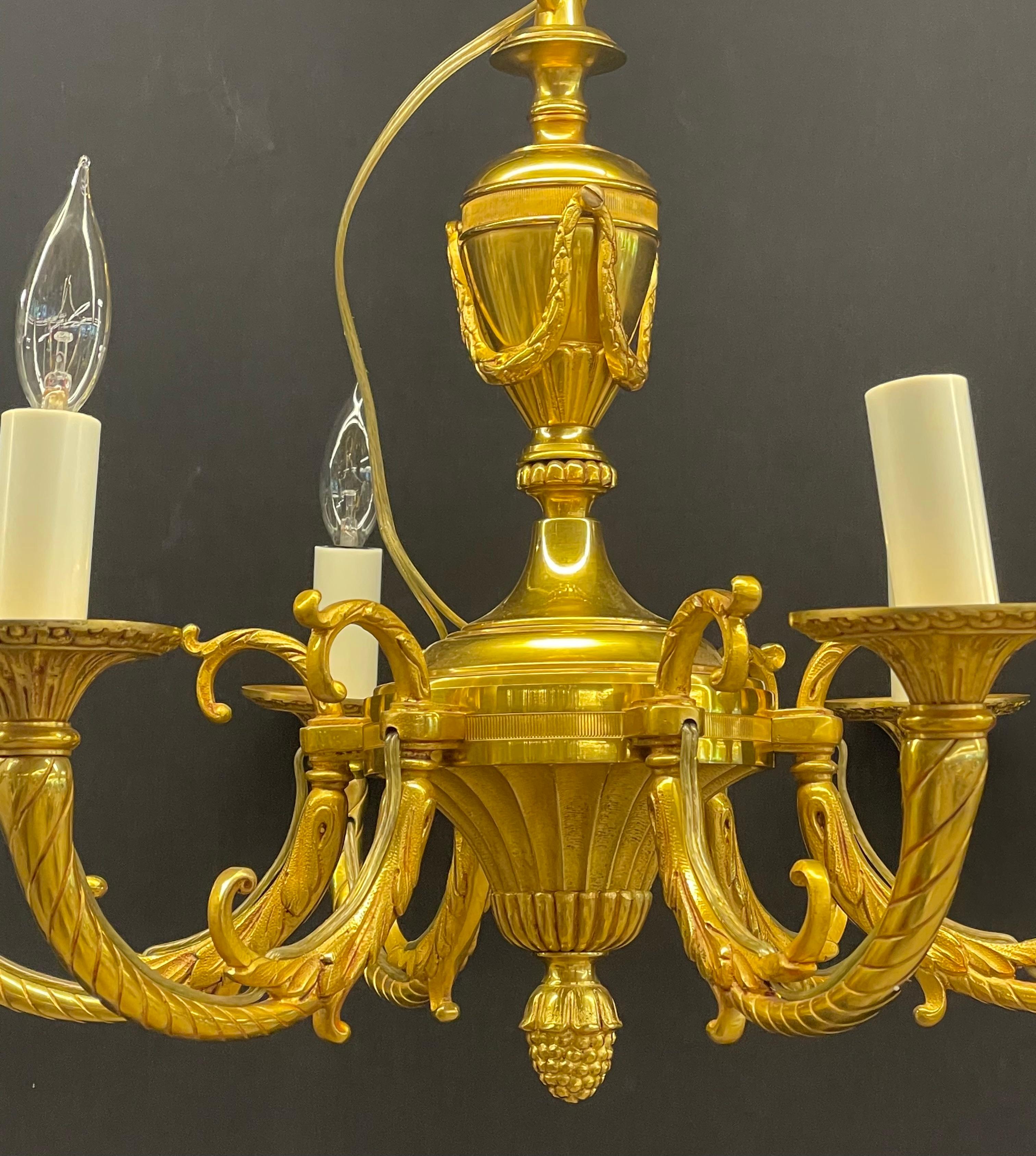 A simply stunning finely cast dore bronze chandelier. This diminutive chandelier has six lights and a continuous flow of swag and laurel bronze features.