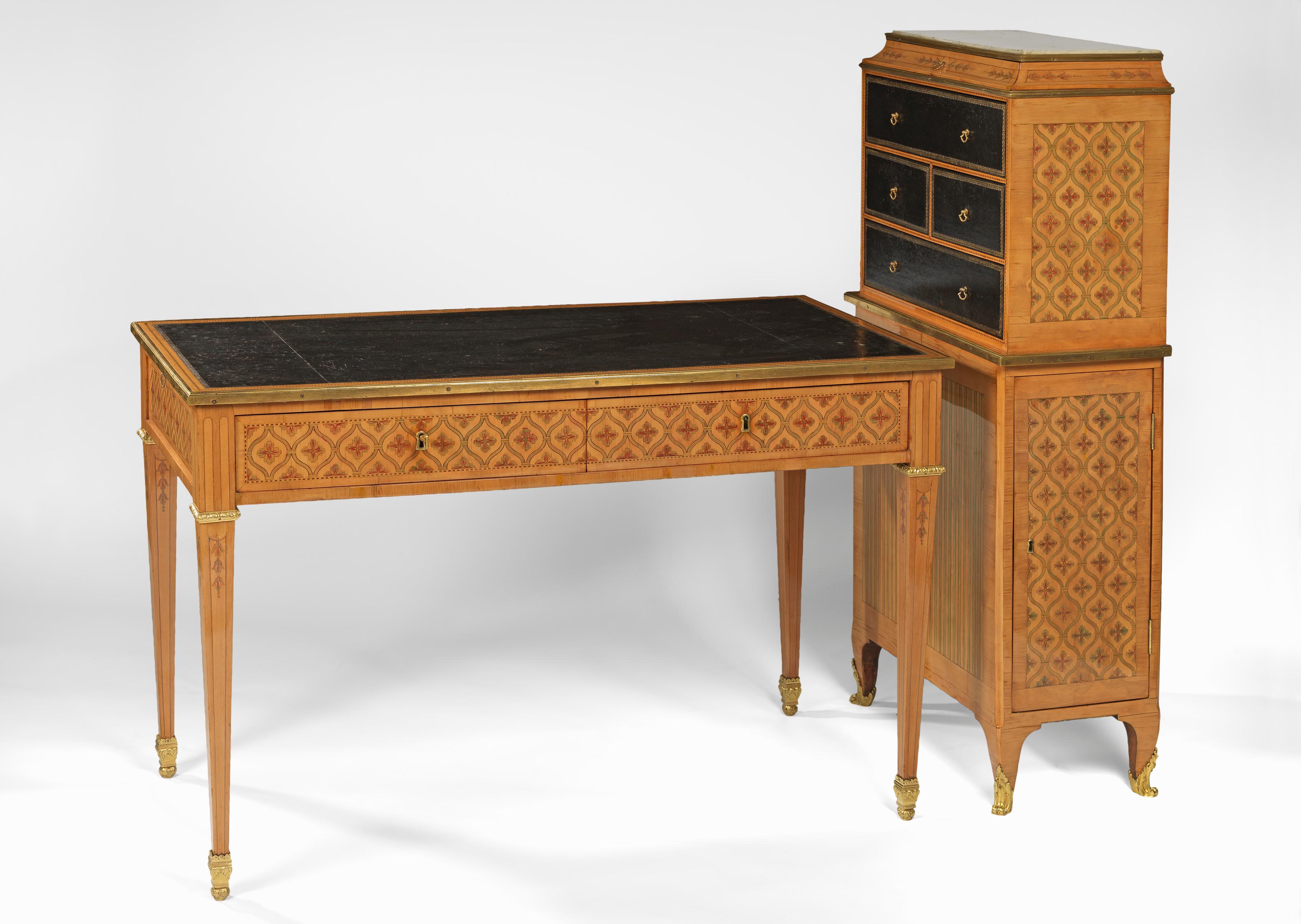 Veneered in rosewood and stained wood of hearts and diamonds intertwined, ornamentation ormolu; the bureau plat, having a rectangular top with a black Moroccan leather, the frieze having two drawers and two pull out sides also covering the same