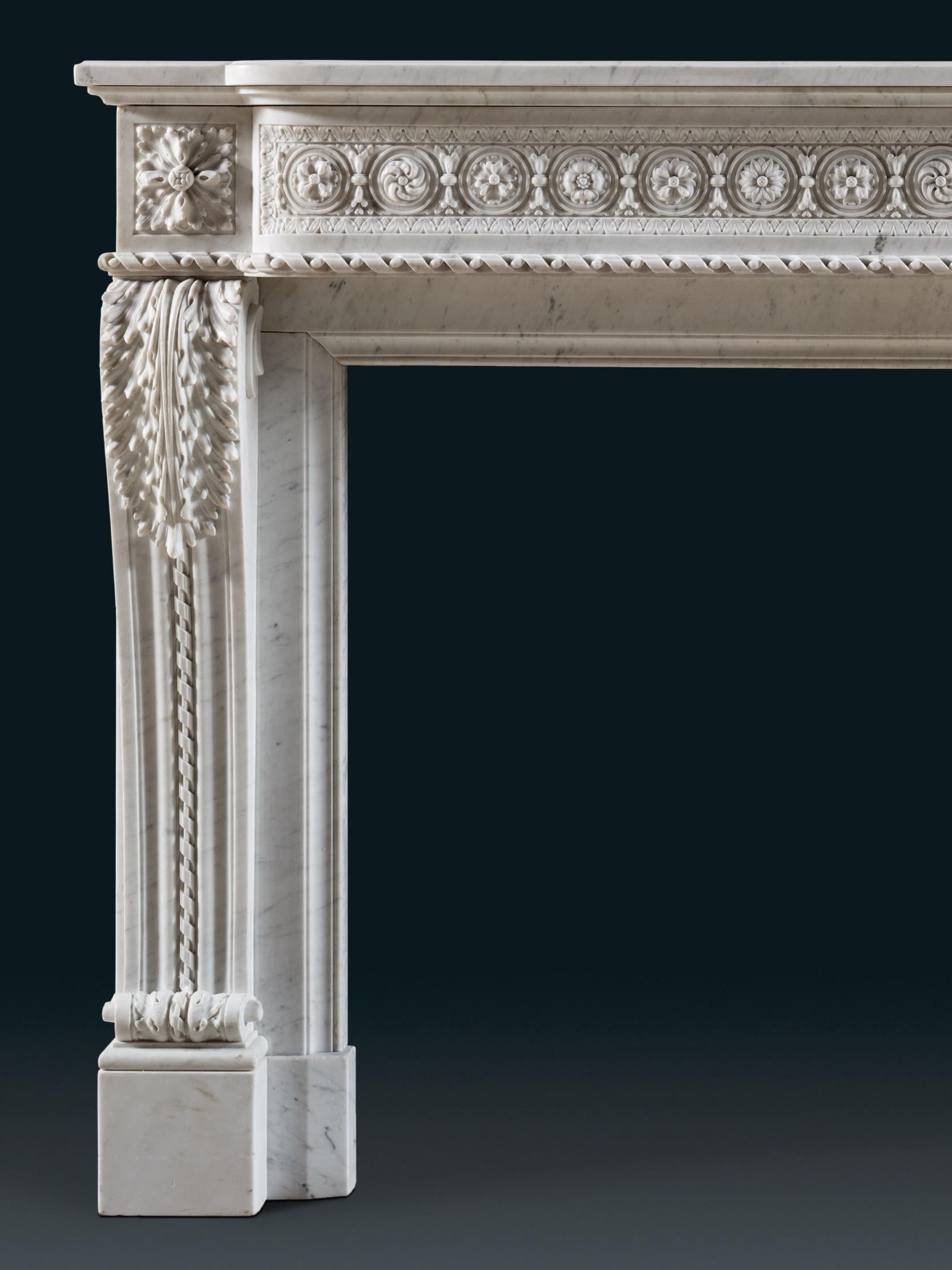 Cheminée Louis XVI composée de jambages en S, d'une frise guillochée et d'une tablette en saillie. La sculpture du marbre blanc est vive et dynamique, mais la délicatesse et l'étendue de la sculpture donnent une impression de somptuosité.