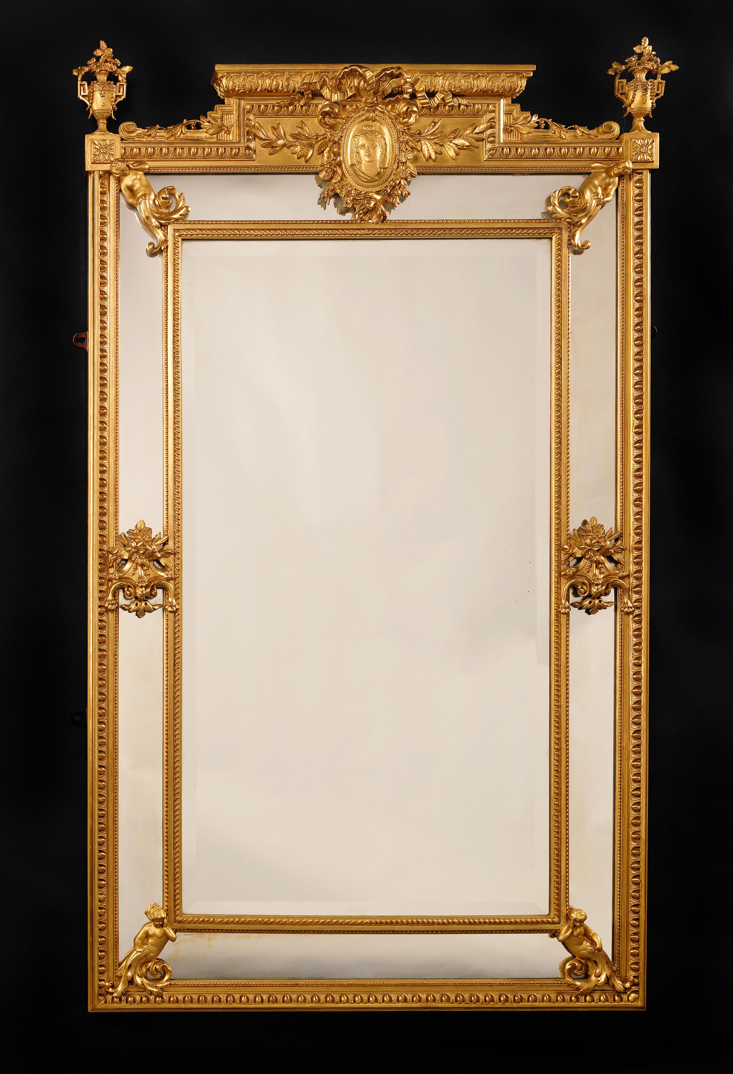 Très beau miroir marginal de style Louis XVI en bois doré sculpté et composition. 

Français, datant d'environ 1890. 

Ce beau miroir présente une bordure godronnée, perlée et ovoïde. Elle est décorée de chérubins dans les angles et centrée par