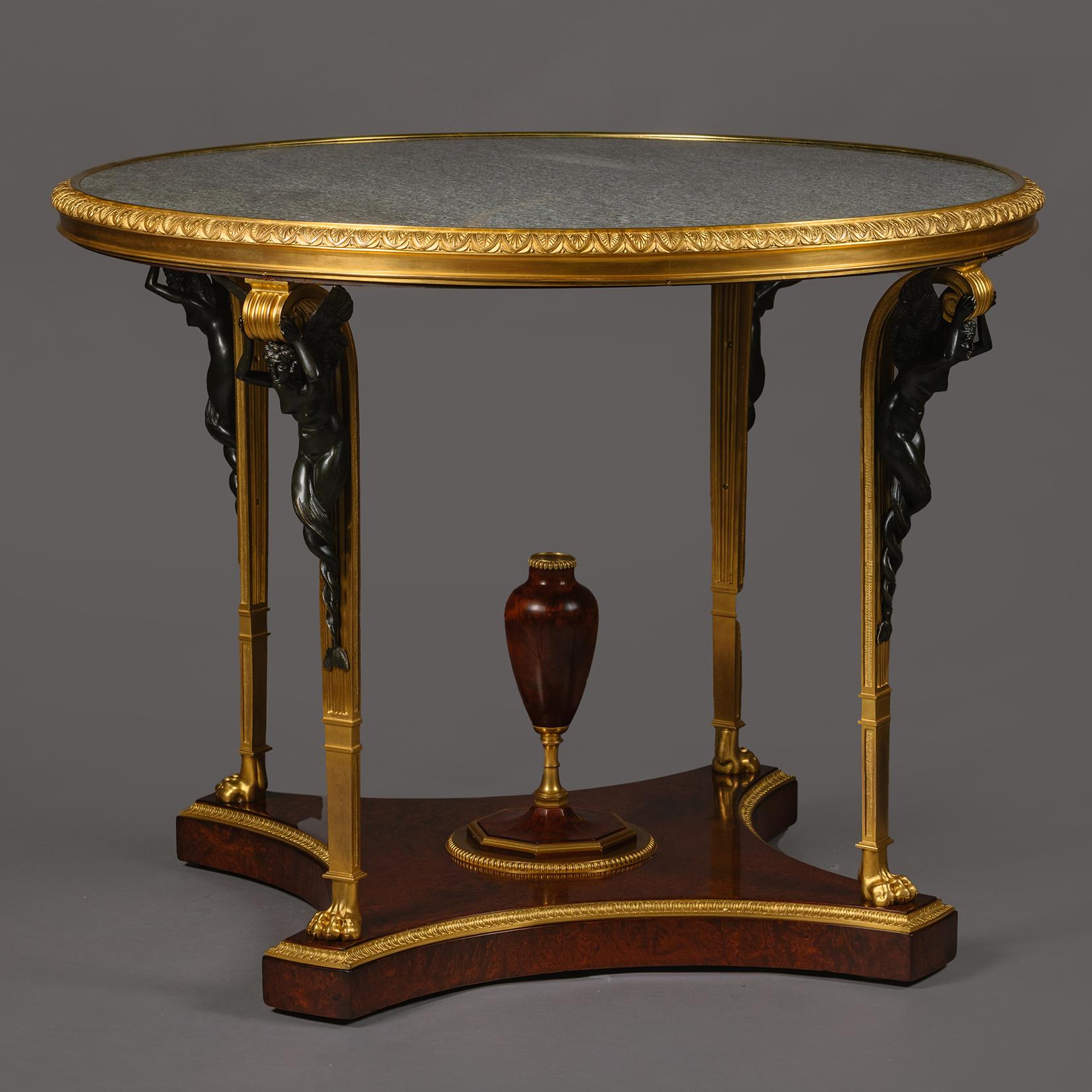 Table centrale de style Louis XVI, patinée et montée en bronze doré, d'après le modèle de Fontainebleau, avec un plateau en marbre Verde Patricia, par Zwiener Jansen Successeur.

Les montures en bronze sont estampillées au revers ''ZJ'' pour Zwiener