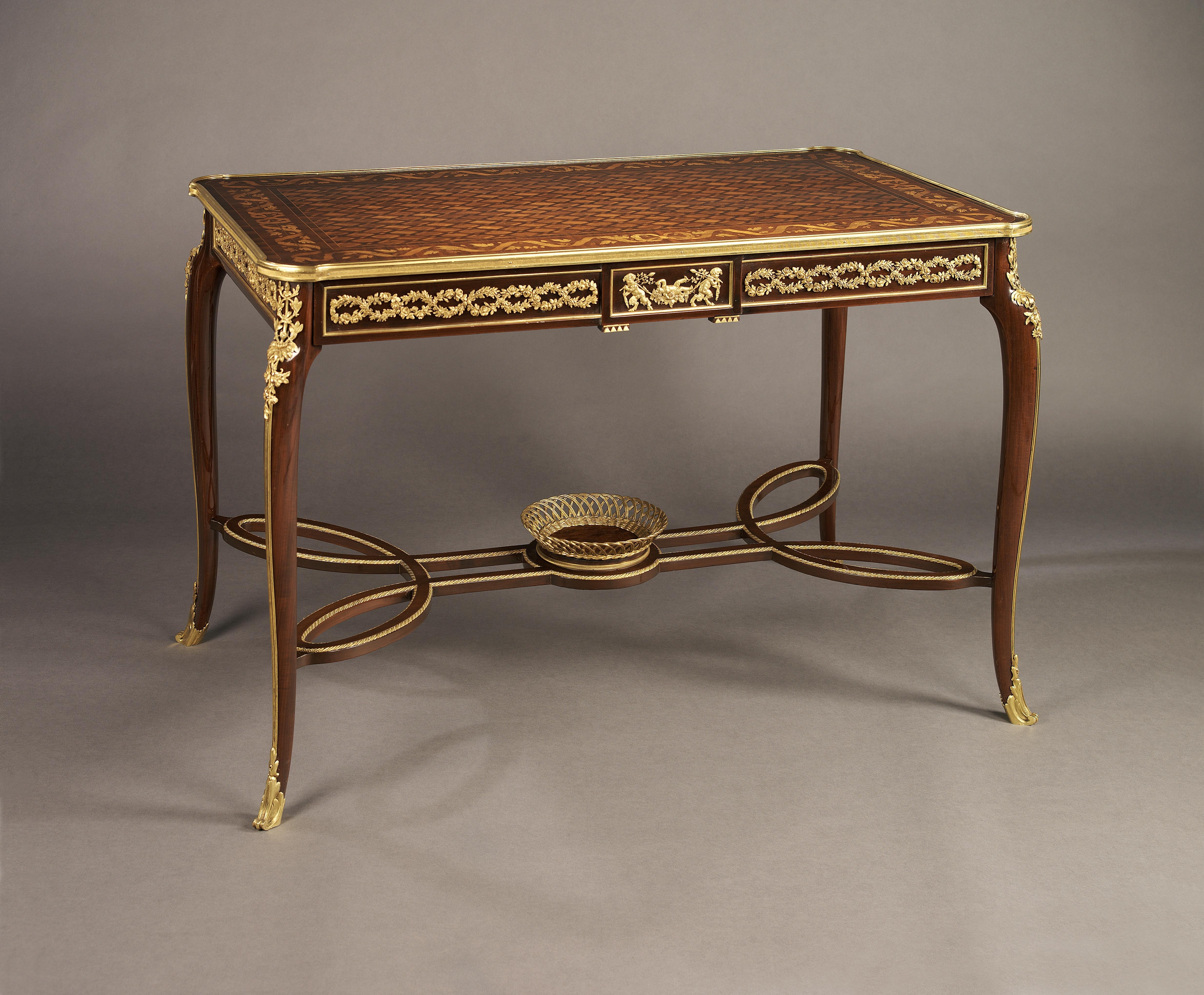 Ein feiner Mahagoni- und Intarsien-Mitteltisch im Louis XVI-Stil mit vergoldeten Bronzebeschlägen, der François Linke zugeschrieben wird.

Frankreich, um 1890.

Dieser feine Intarsientisch hat einen Fries mit einem vergoldeten bronzenen Mäander,