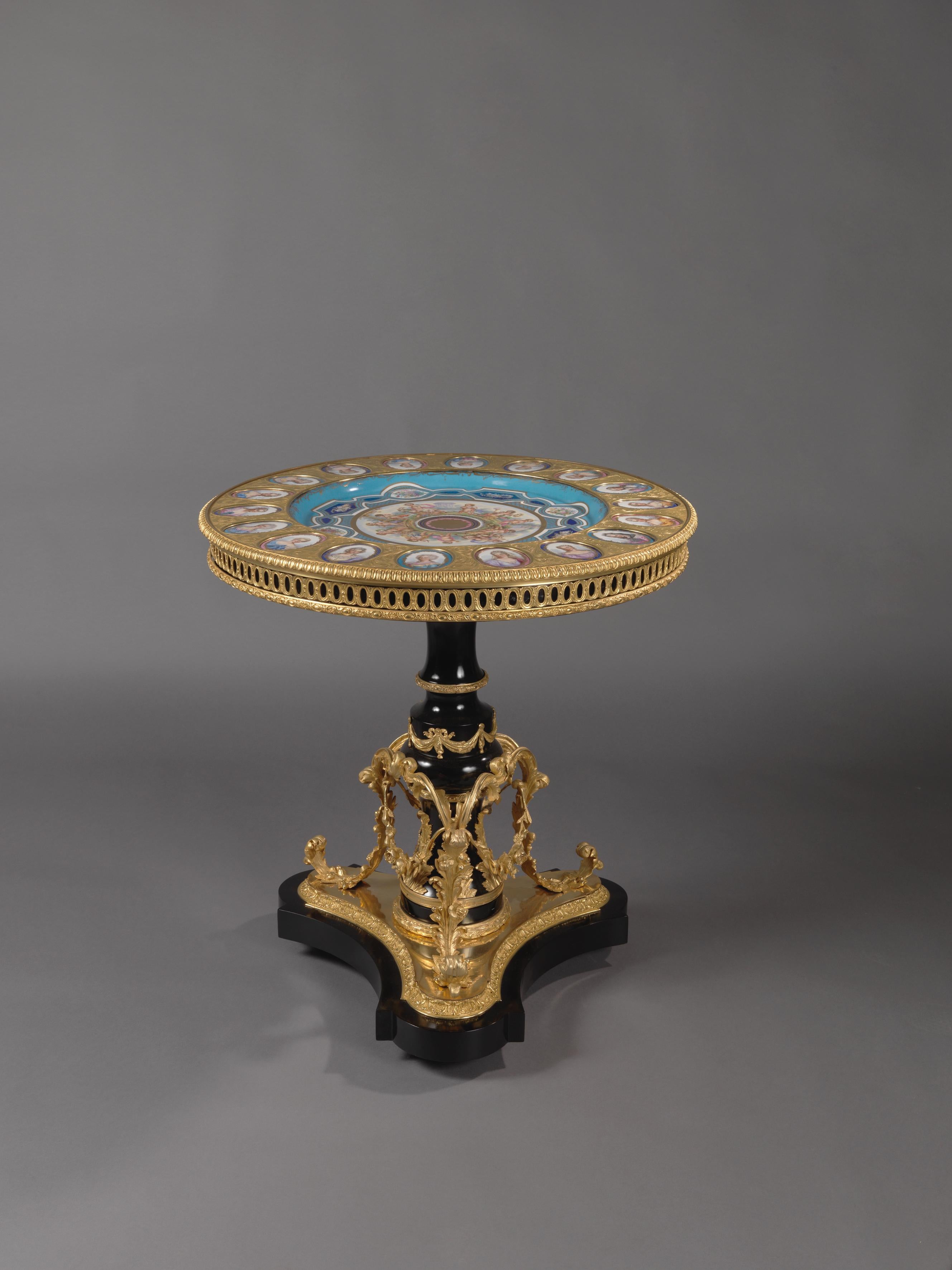 A fine Louis XVI style gilt bronze-mounted ebonised gueridon with Sèvres-style porcelain plaques.

French, circa 1870. 

Stamped to the reverse of the gilt-bronze mounts ‘HB’.

The porcelain plaques with underglaze interlaced Sèvres marks to