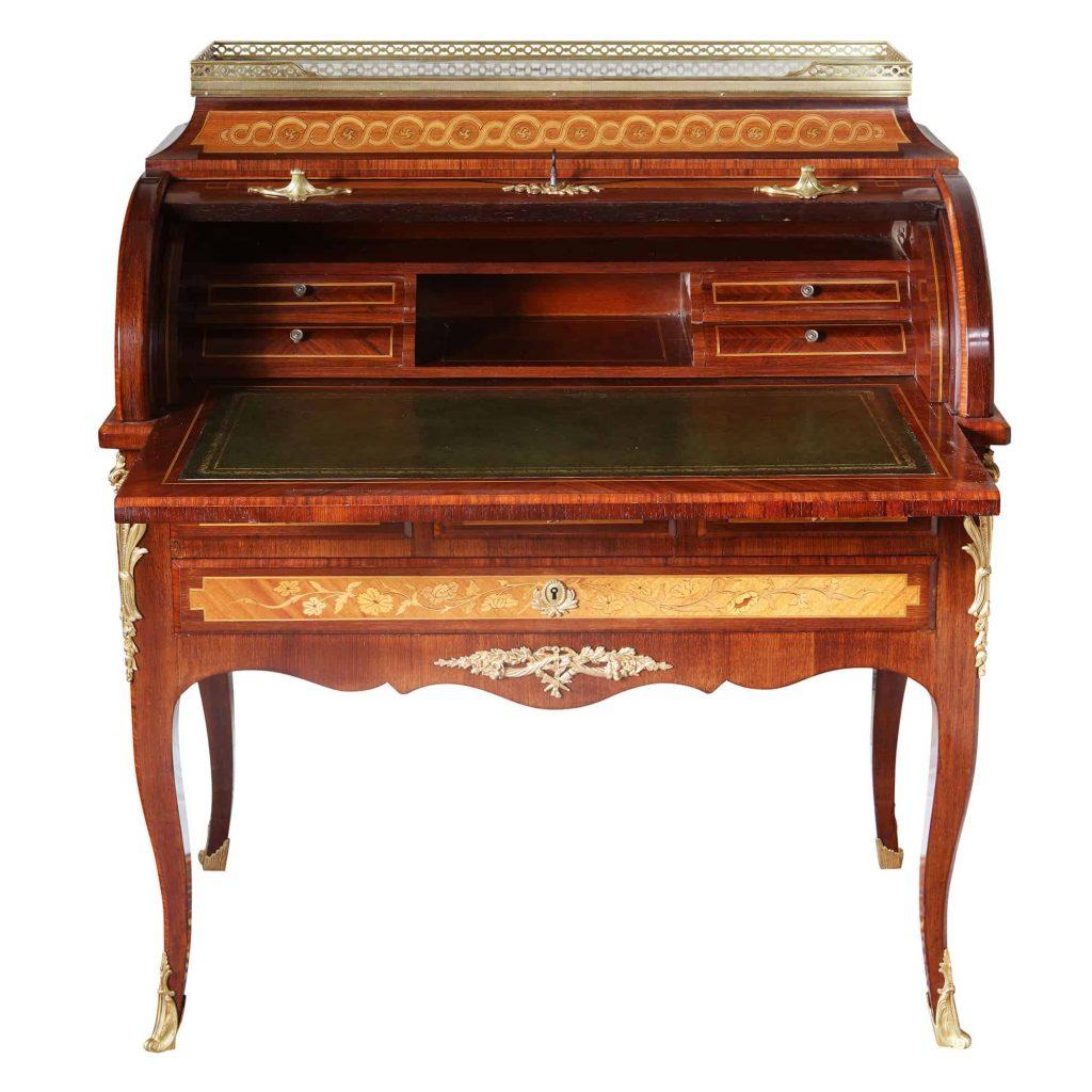 A fine 19th century roll top bureau de damme in the Louis XVI style, with fine veneers and panels of floral and musical inspired marquetry, the superstructure with a pierced brass gallery and Breche Violette marble top, above a marquetry roll top