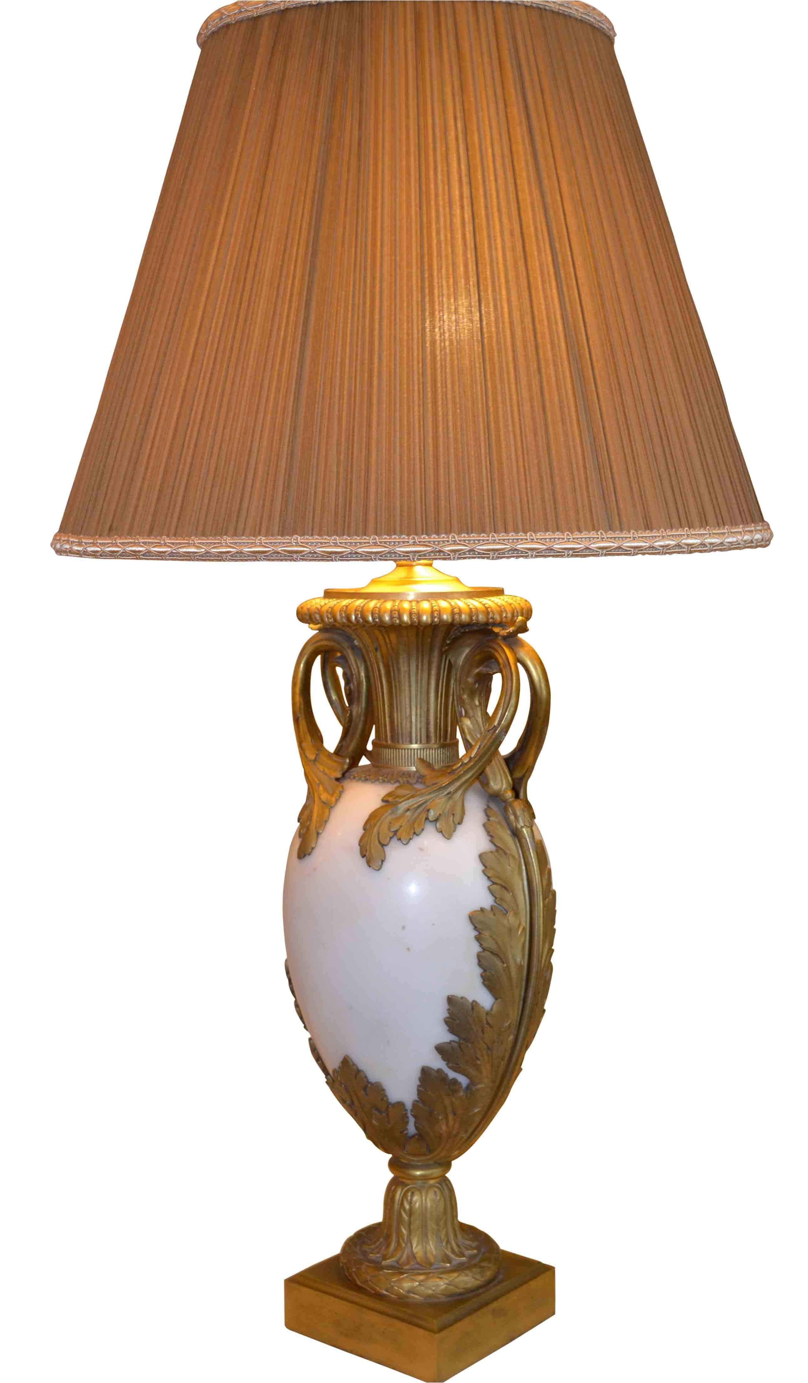 A fine quality Louis XVI style gilt bronze and white marble classically shaped urn now converted to a lamp. The egg shaped white marble body is richly mounted in finely chased gilded bronze, pleated silk beige shade.