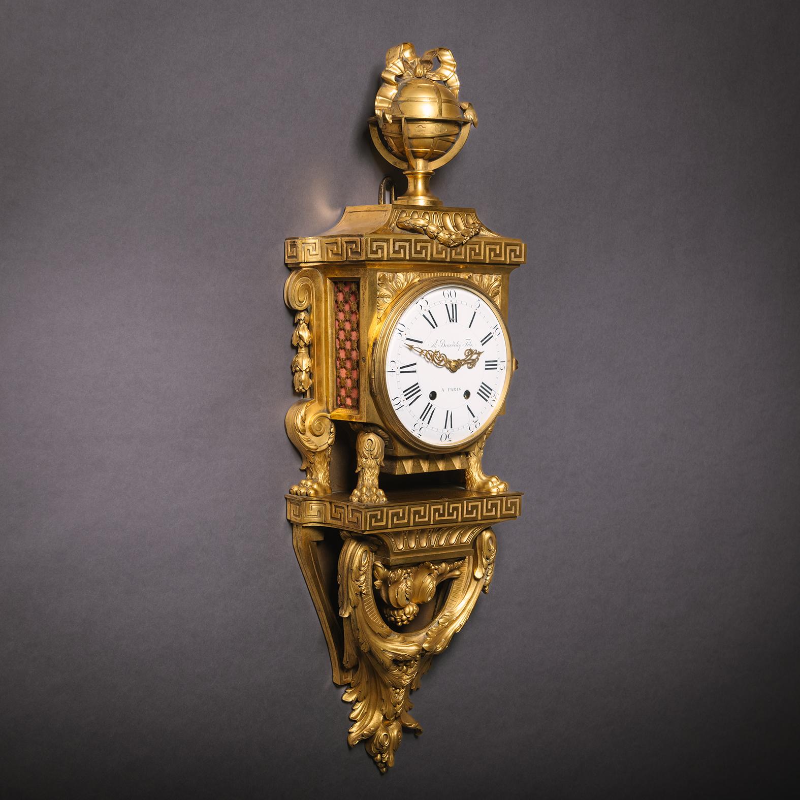 Un raffinato orologio di cartello in stile Luigi XVI in bronzo dorato, di Beurdeley.  

Firmato 'A Beurdeley Fils à Paris'.

Sormontata da un globo legato da un nastro, la cassa in bronzo dorato di questo raffinato orologio di cartello presenta un