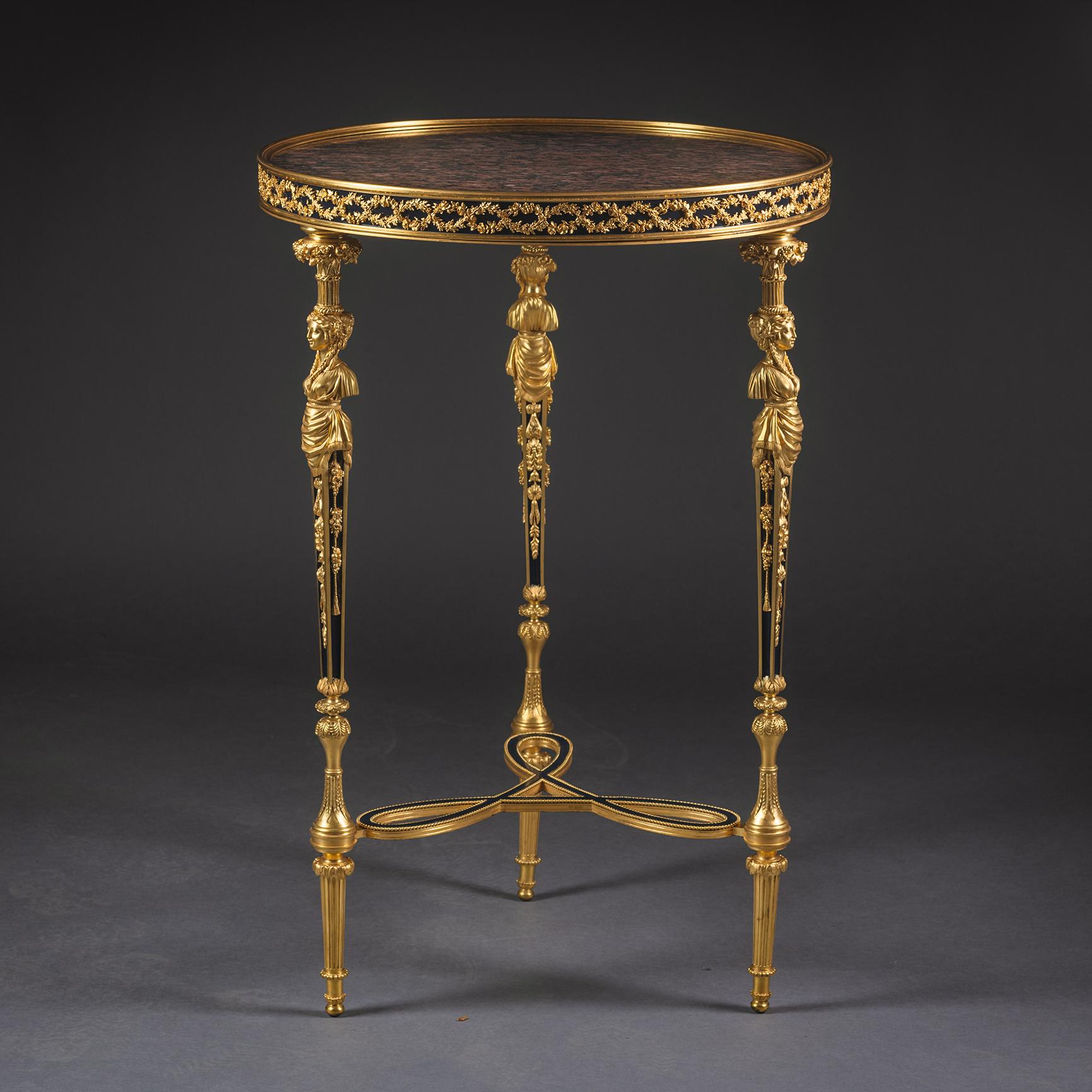 Guéridon en bronze doré de style Louis XVI à la manière d'Adams.

Ce beau guéridon présente un plateau circulaire en granit rouge surmonté d'une frise moulée de lauriers et de roses, reposant sur quatre pieds effilés coiffés de cariatides