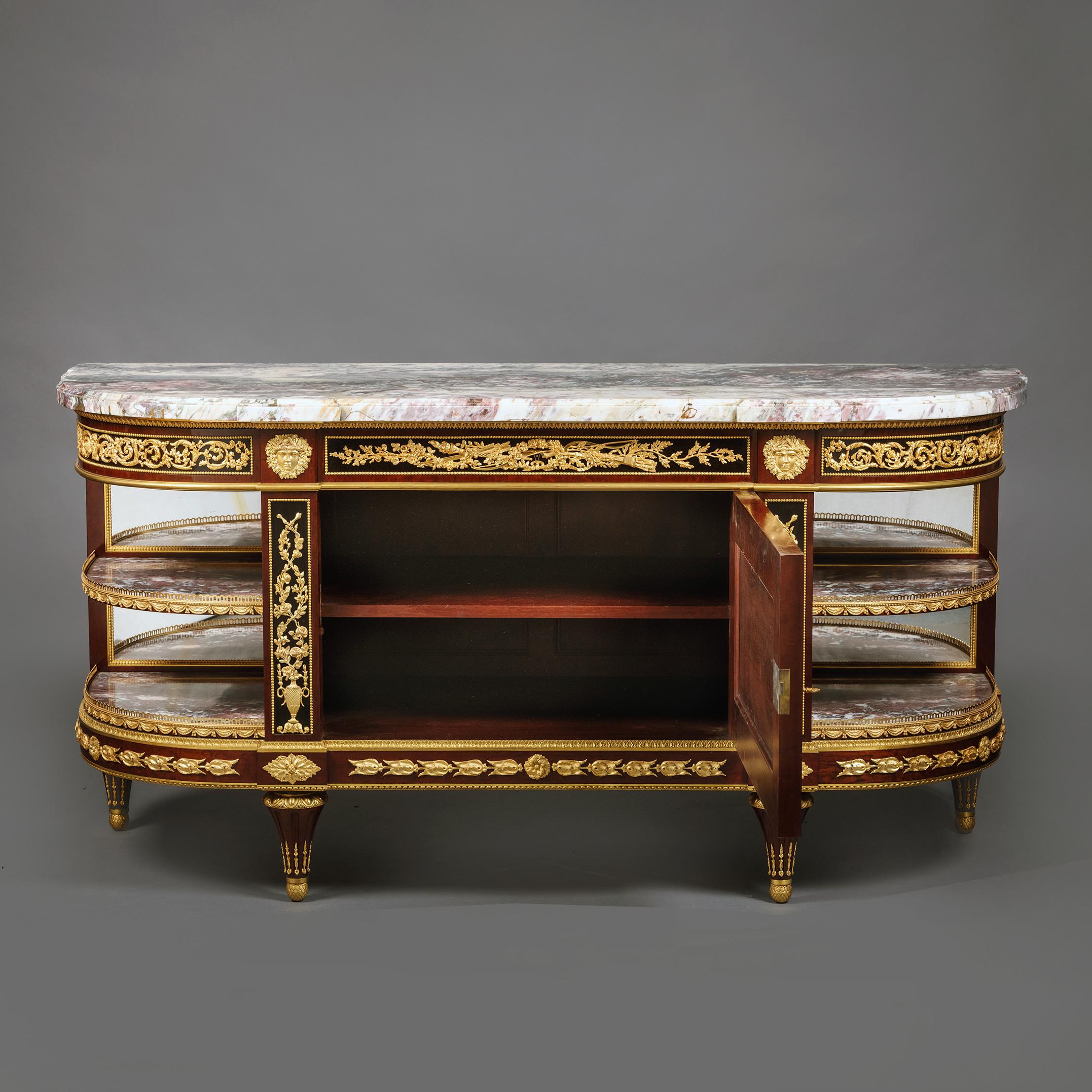 A Louis XVI Style Gilt-Bronze Mounted Mahogany and Ebonised Commode à l'Anglaise.

The original marble top of Italian fleur de pêcher marble. The centre frieze drawer applied with neo-classical attributes of love including cupid’s bow amidst floral