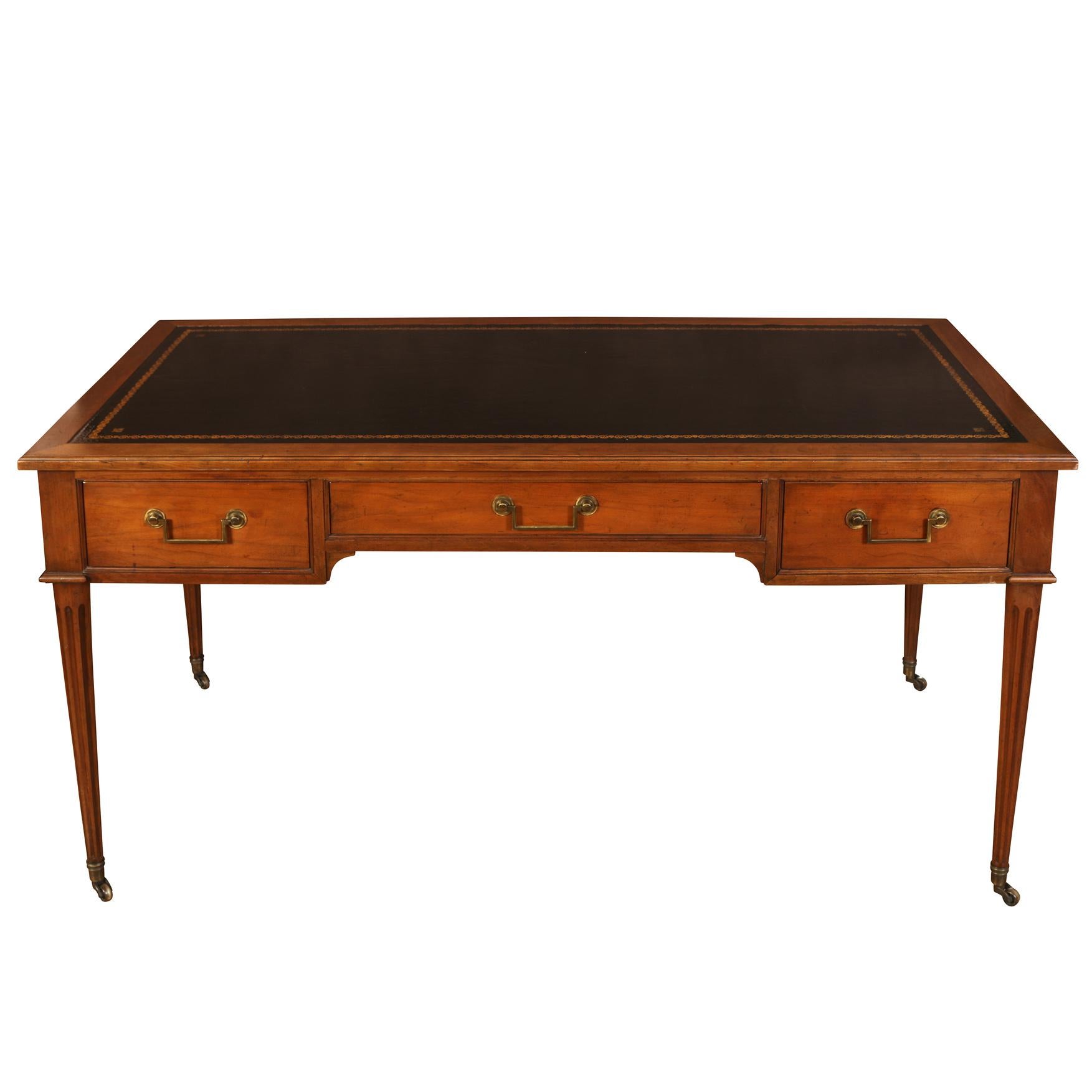 A very nice looking mahogany Louis XVI style bureau plat. The clean lines of the desk give it an understated elegance. Its rectangular top has an inset writing surface of black tooled leather and sits above three drawers with original brass pulls.