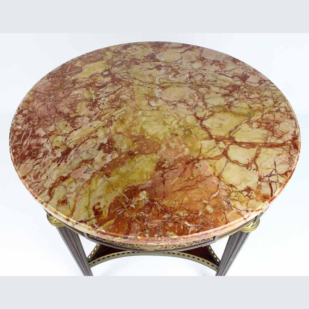 Ein runder Tisch im Louis XVI-Stil mit Ormolu-Montierung und roter Marmorplatte.
Markiert auf der Platte: 