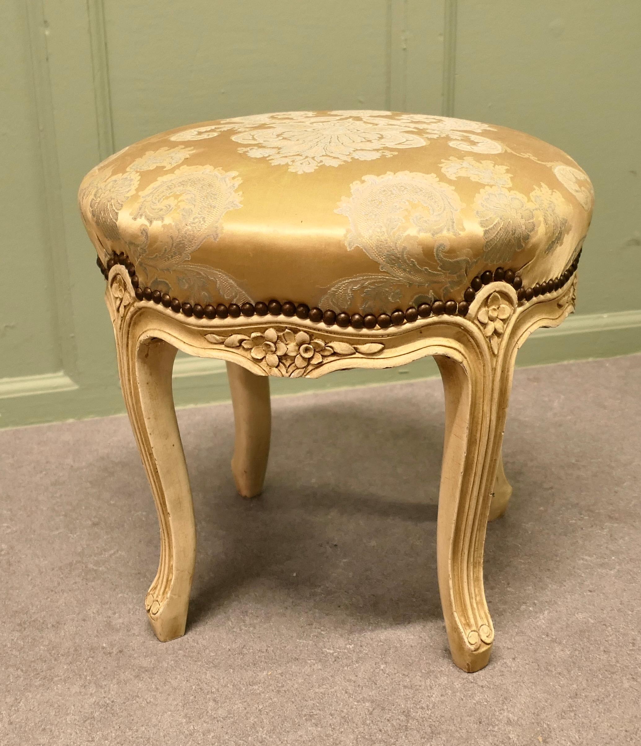 A Louis XVI style Painted Circular Boudoir Stool

A Dainty piece yet a sturdy stool, which stands on 4 carved cabriole legs, the seat is upholstered in its original gold and cream satin brocade. 
The stool has sprung seat, is in very good