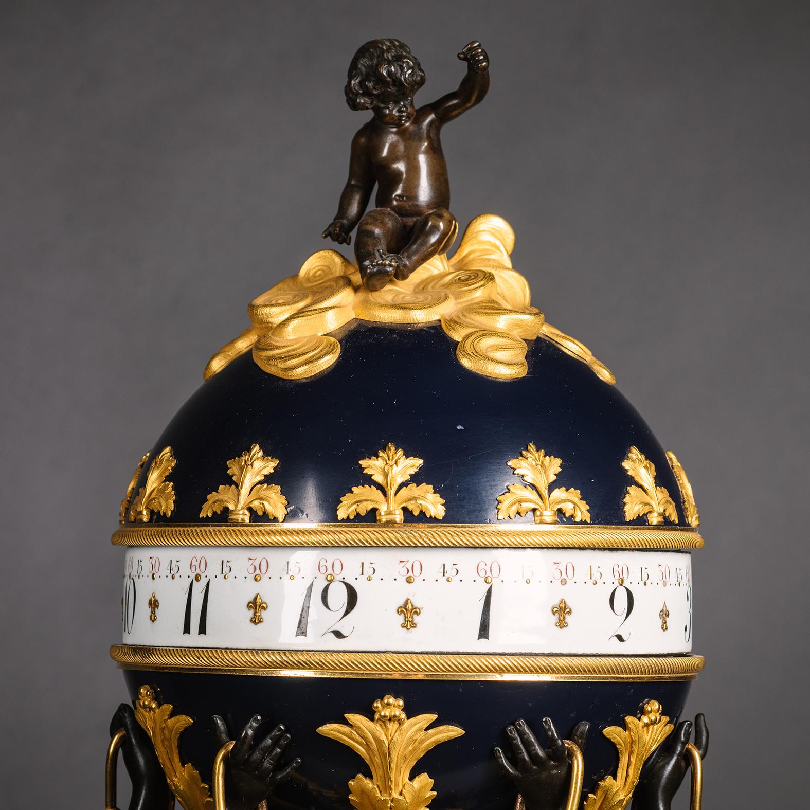 A Louis XVI Style Gilt and Patinated Bronze and Marble Three Graces Spherical Clock. By Emmanuel-Alfred (Dit Alfred II) Beurdeley. 

Modelled in bronze with the Three Graces holding flower chains and aloft a sphere surmounted by a cloudborne figure
