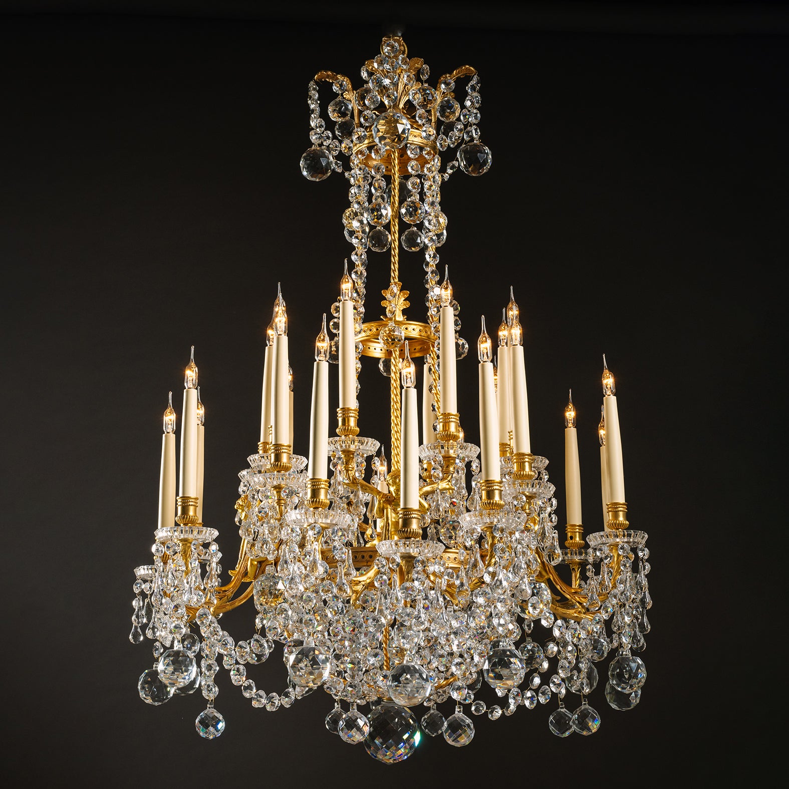 Fina araña de veinticuatro luces de bronce dorado y cristal moldeado, estilo Luis XVI, de La Compagnie des Cristalleries De Baccarat.

Firma 