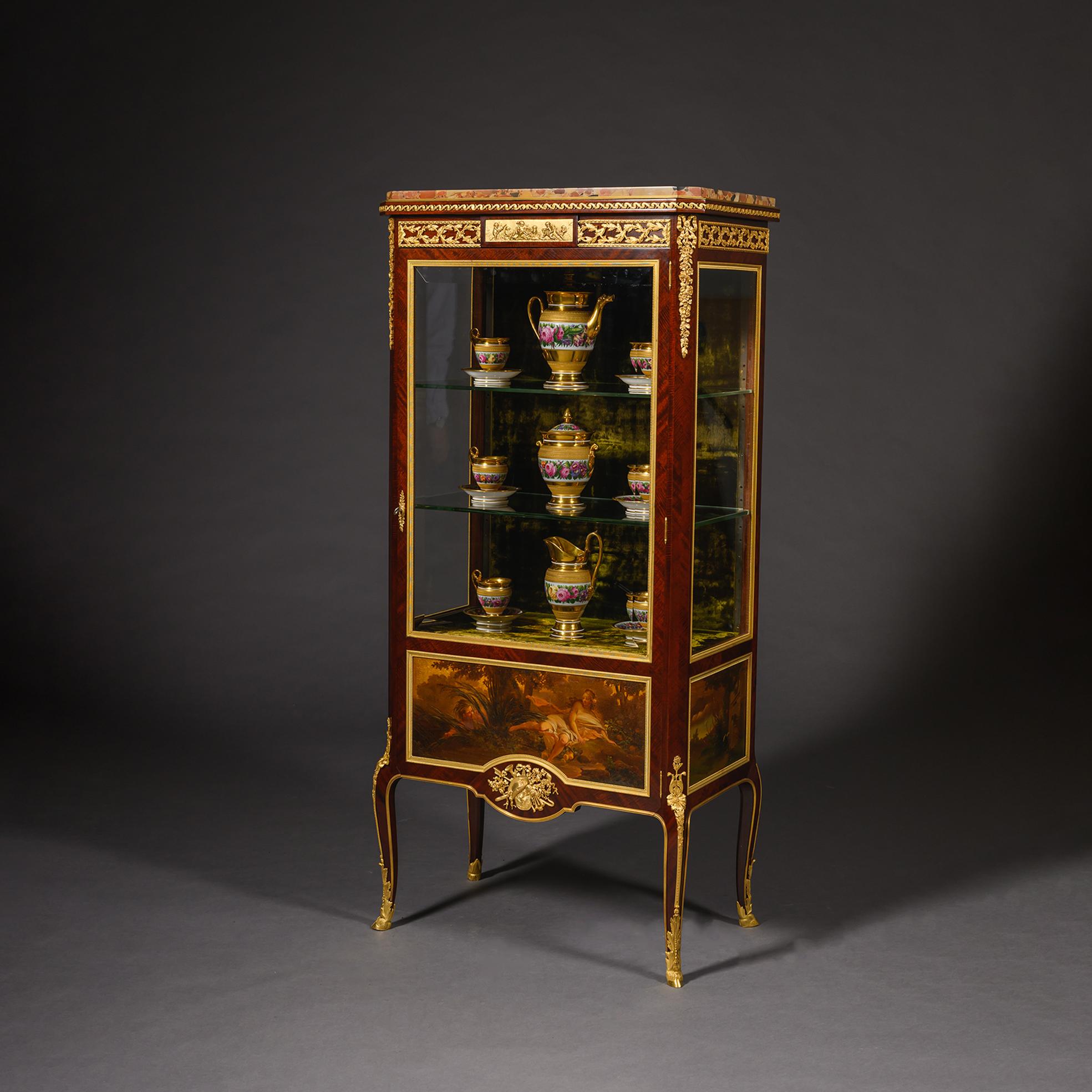 A Louis XVI Style Gilt-Bronze Mounted And Vernis Martin Decorated Mahogany Vitrine Cabinet, By François Linke, Paris. 

The inset brêche d’Alep marble top above a Vitruvian scroll mounted frieze with vine and a plaque of playful putti. The glazed