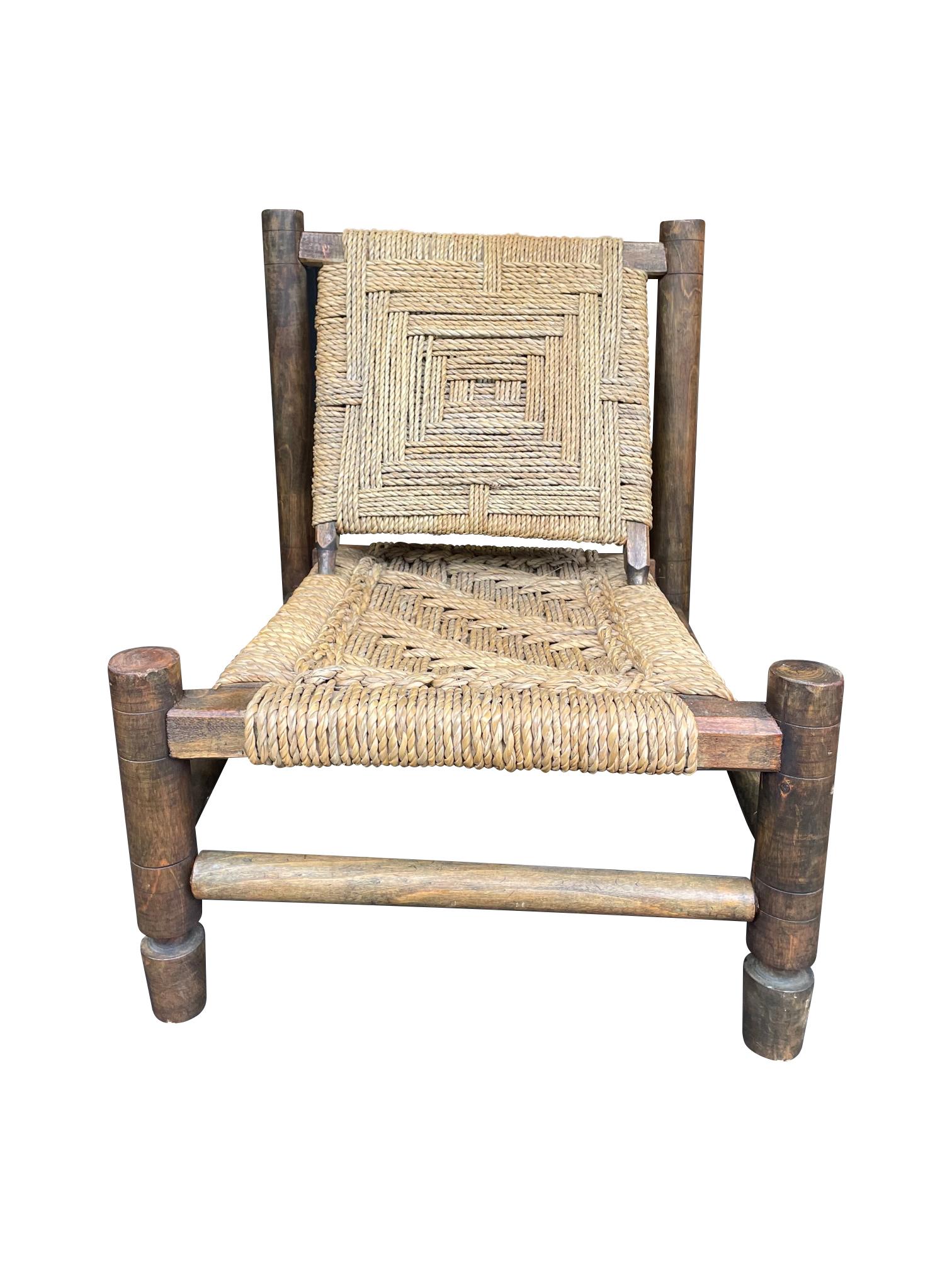 A lovely 1950s rustic French Rope and wood chair by Adrien Audoux and Frida Minet, with hand woven rope seat and back in a geometric pattern on a stained hand turned wooden frame. 

Adrien Audoux and Frida Minet designed rustic style furniture